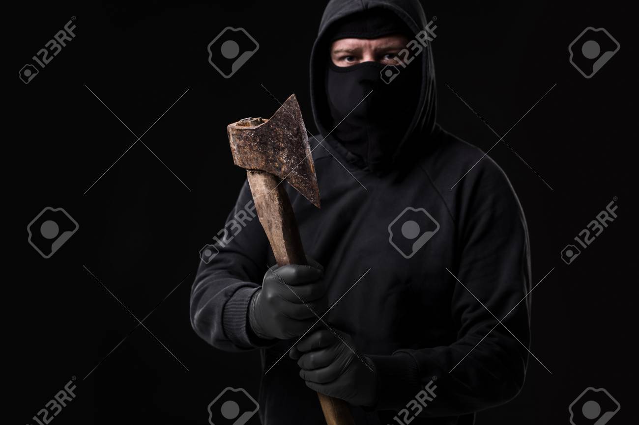 Bandit In Black Mask With Hatchet On Background Stock Photo