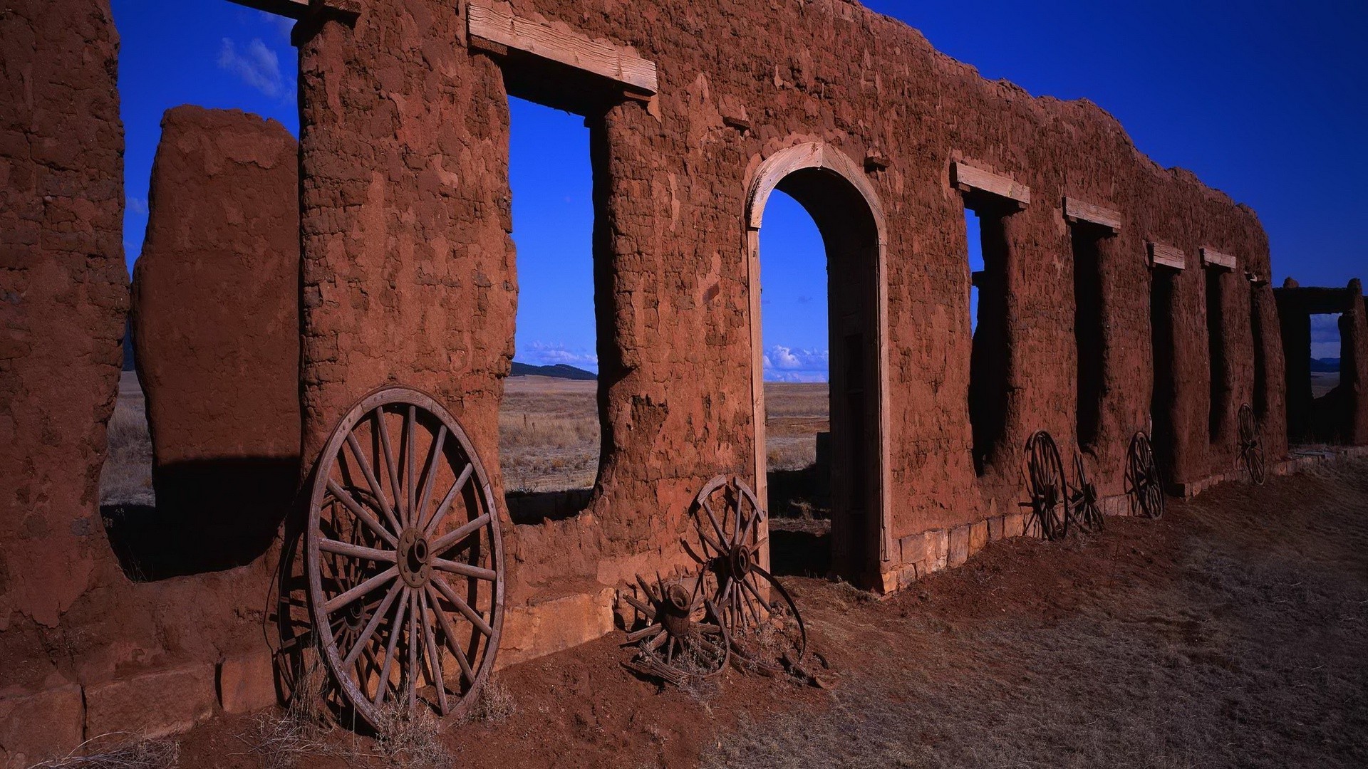 Cart Wheels Against Fort Ruins Wallpaper