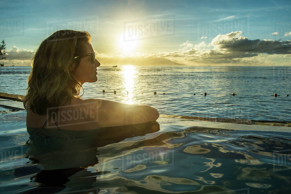 Woman Enjoying The Sunset In A Swimming Pool With Moorea