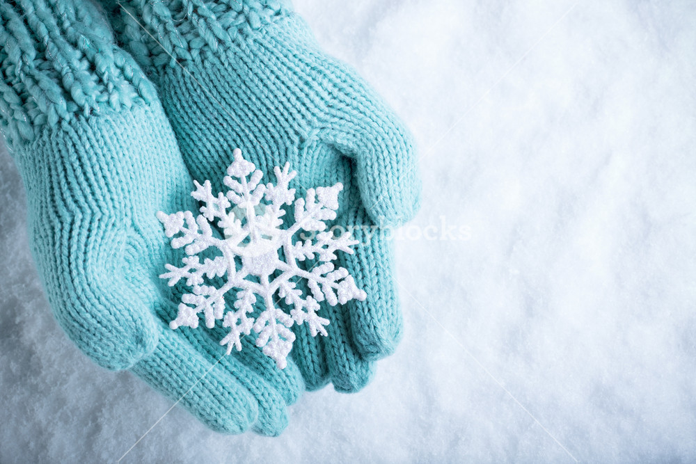 Female Hands In Light Teal Knitted Mittens With Sparkling