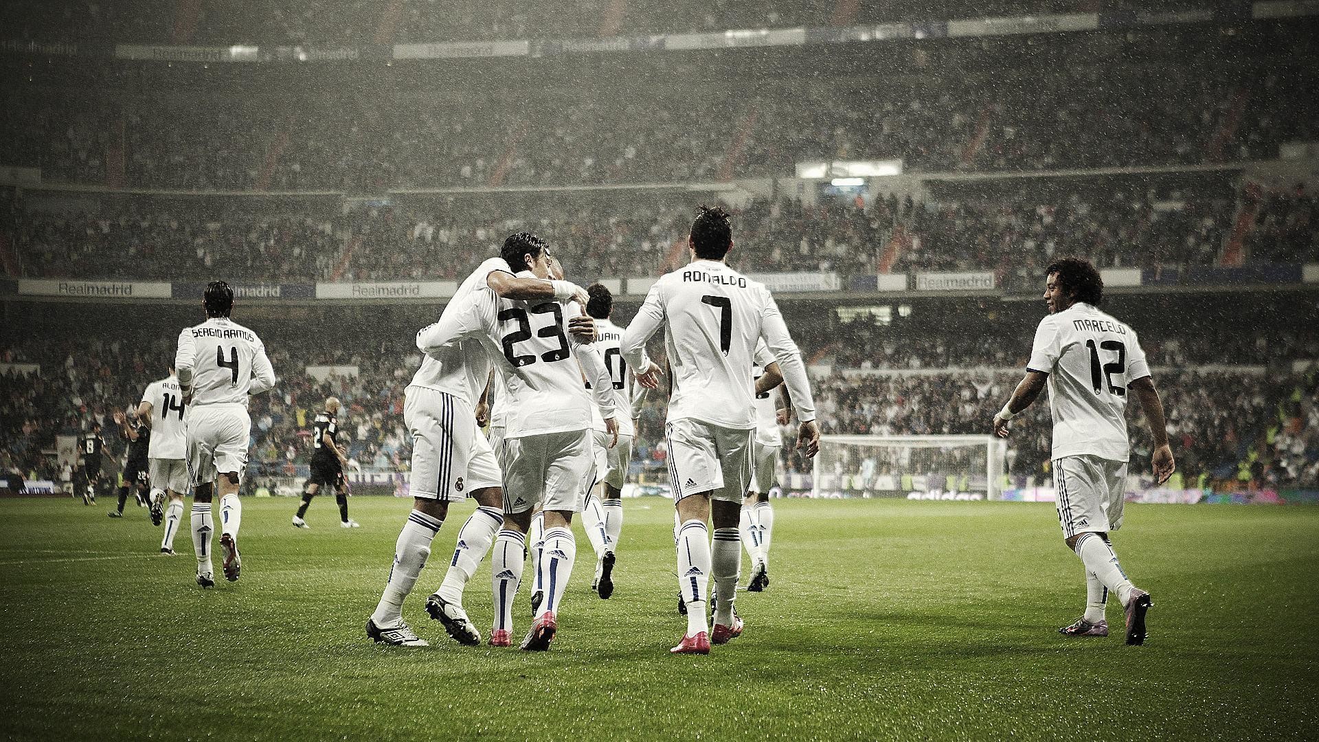 Real Madrid players celebrating a goal in the rain during a Nike-sponsored football match