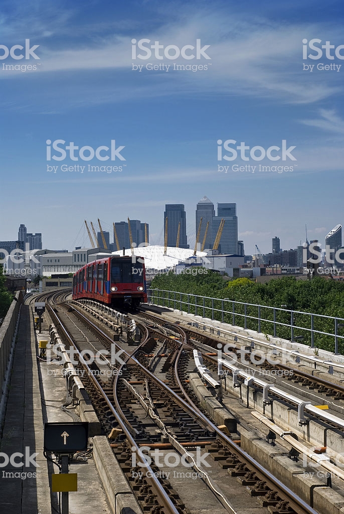 Dlr Approaching Station Canary Wharf In The Background Stock Photo