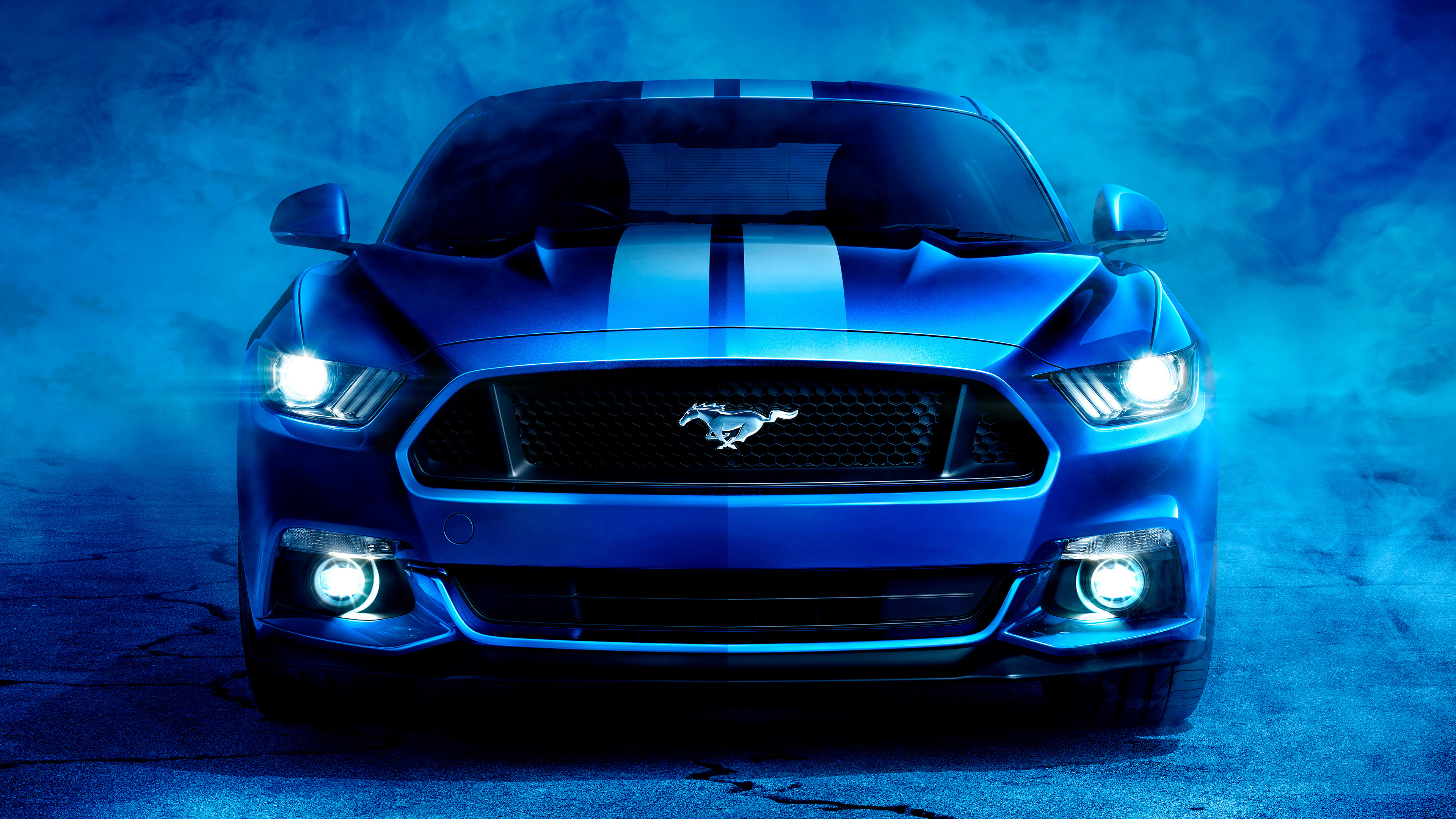 Blue Ford Mustang sports car with racing stripes against a smoky backdrop