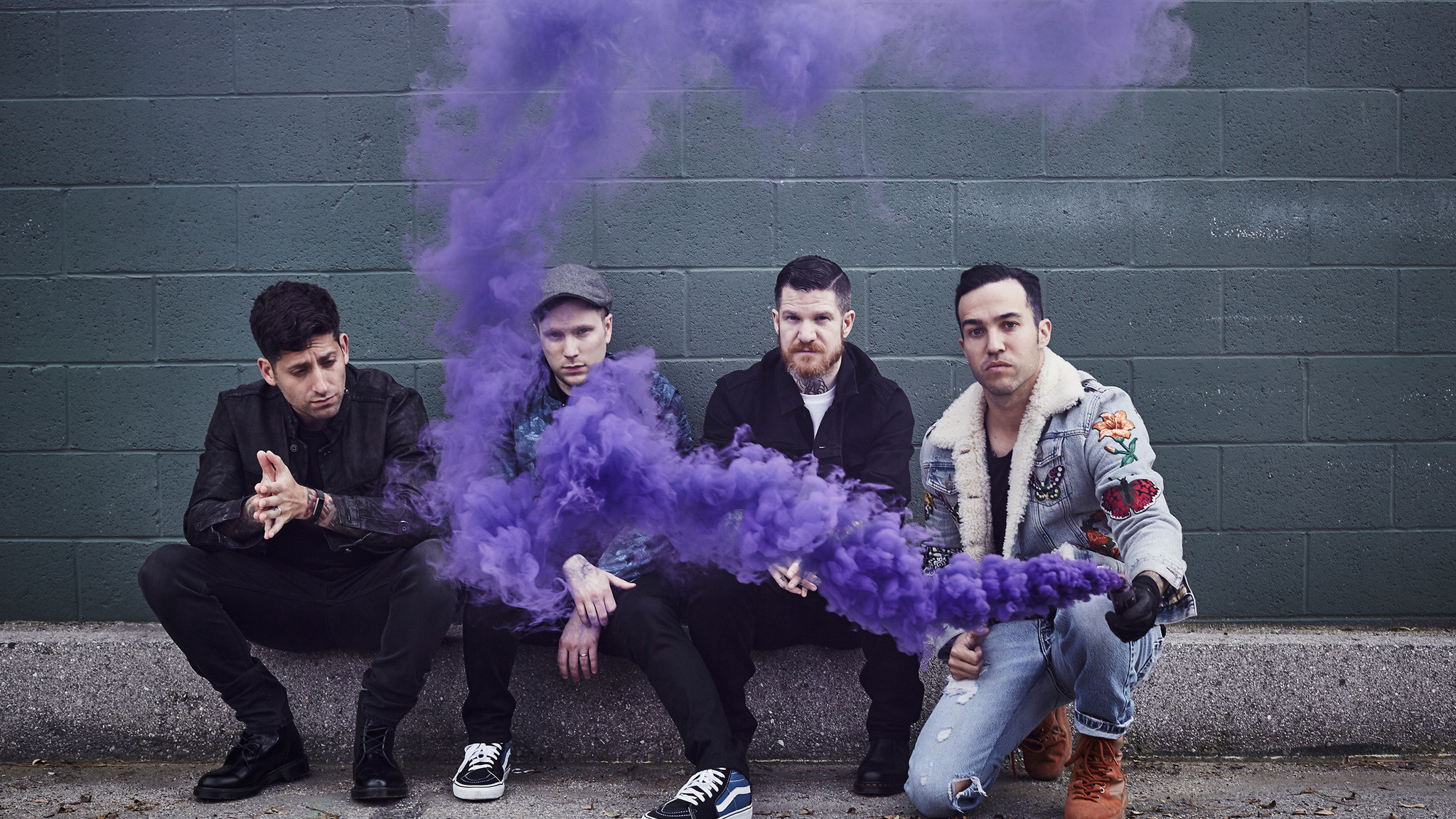 Promotional photo of the band Fall Out Boy with purple smoke