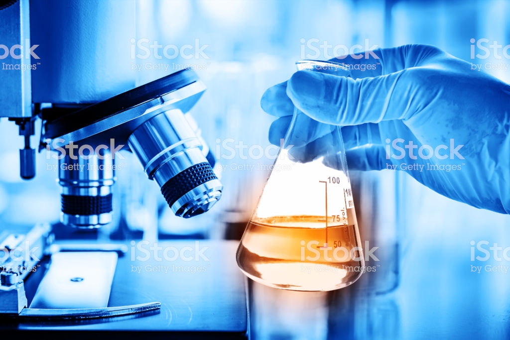 Flask In Scientist Hand With Lab Microscope Background