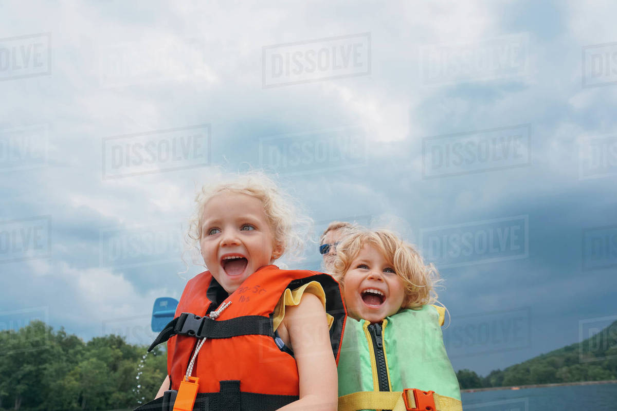 Low Angle Of Sisters In Canoe With Father Background