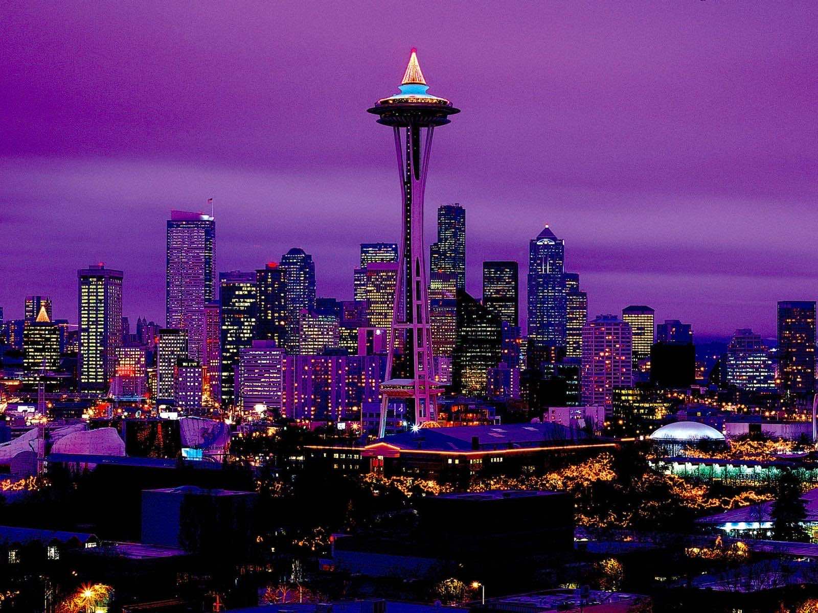 Seattle skyline at night with the Space Needle illuminated in purple