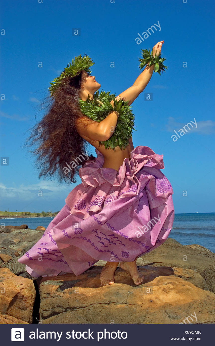 Hula Dancer With Haku Lei In Traditional Outfit On Rocky Coast