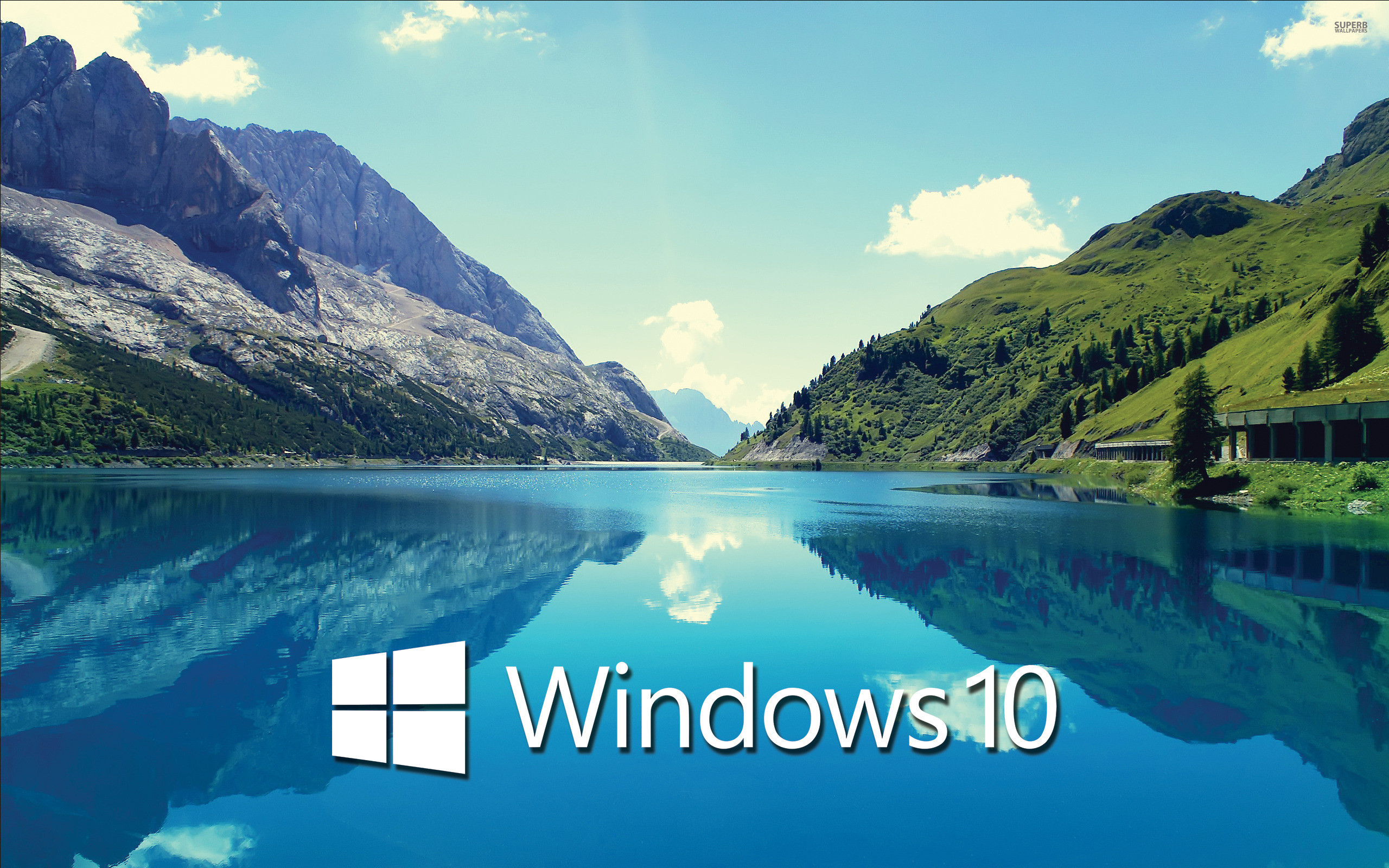 Serene lake reflecting mountains in a Windows 10 wallpaper