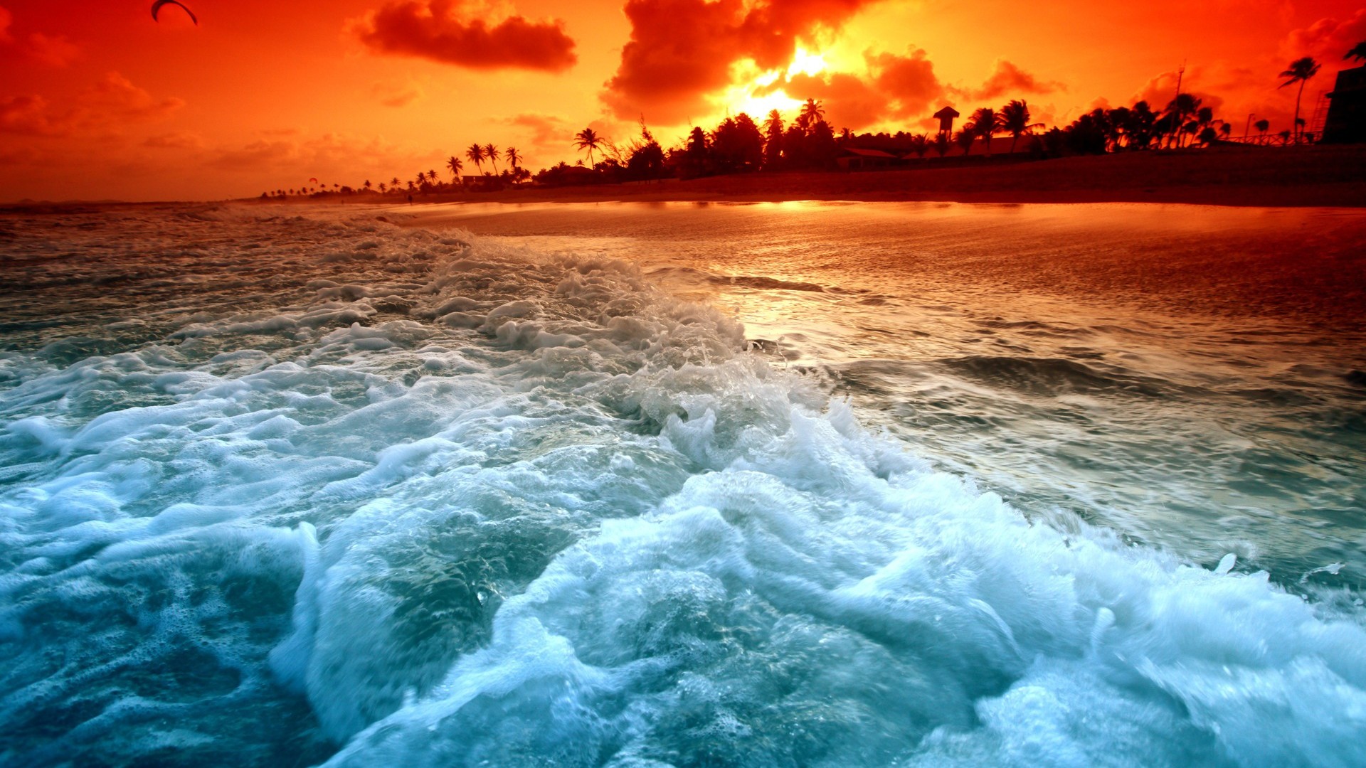 Vivid sunset over a tropical beach with turquoise waves crashing on the shore