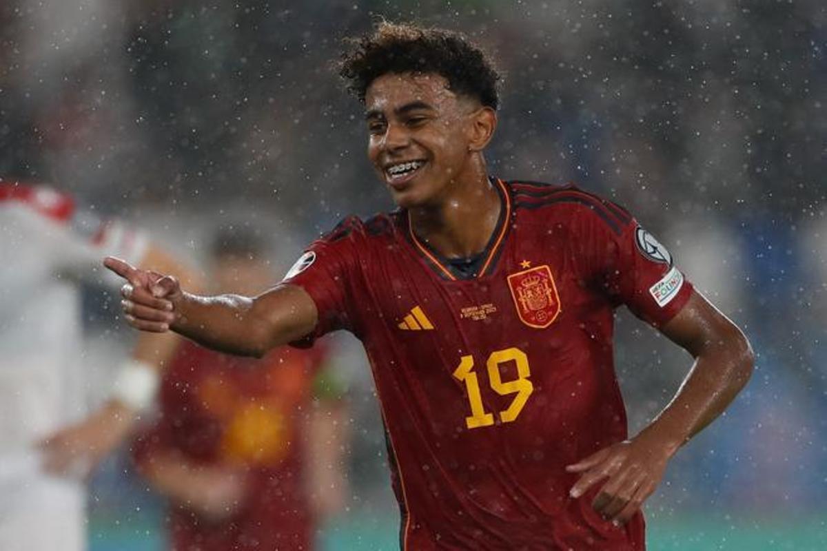 Lamine Yamal celebrates in the rain during a soccer match for Spain, showcasing his joy after a play