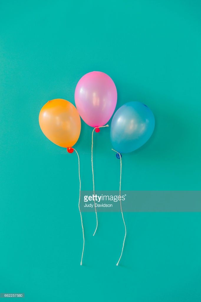 Three Balloons On Strings A Plain Turquoise Background With