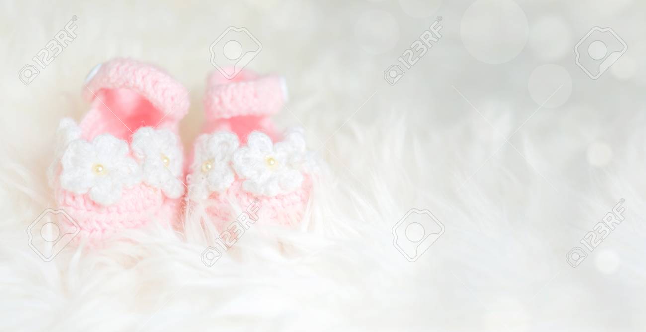 Close Up Baby Girl Knitted Shoes On White Blanket Background