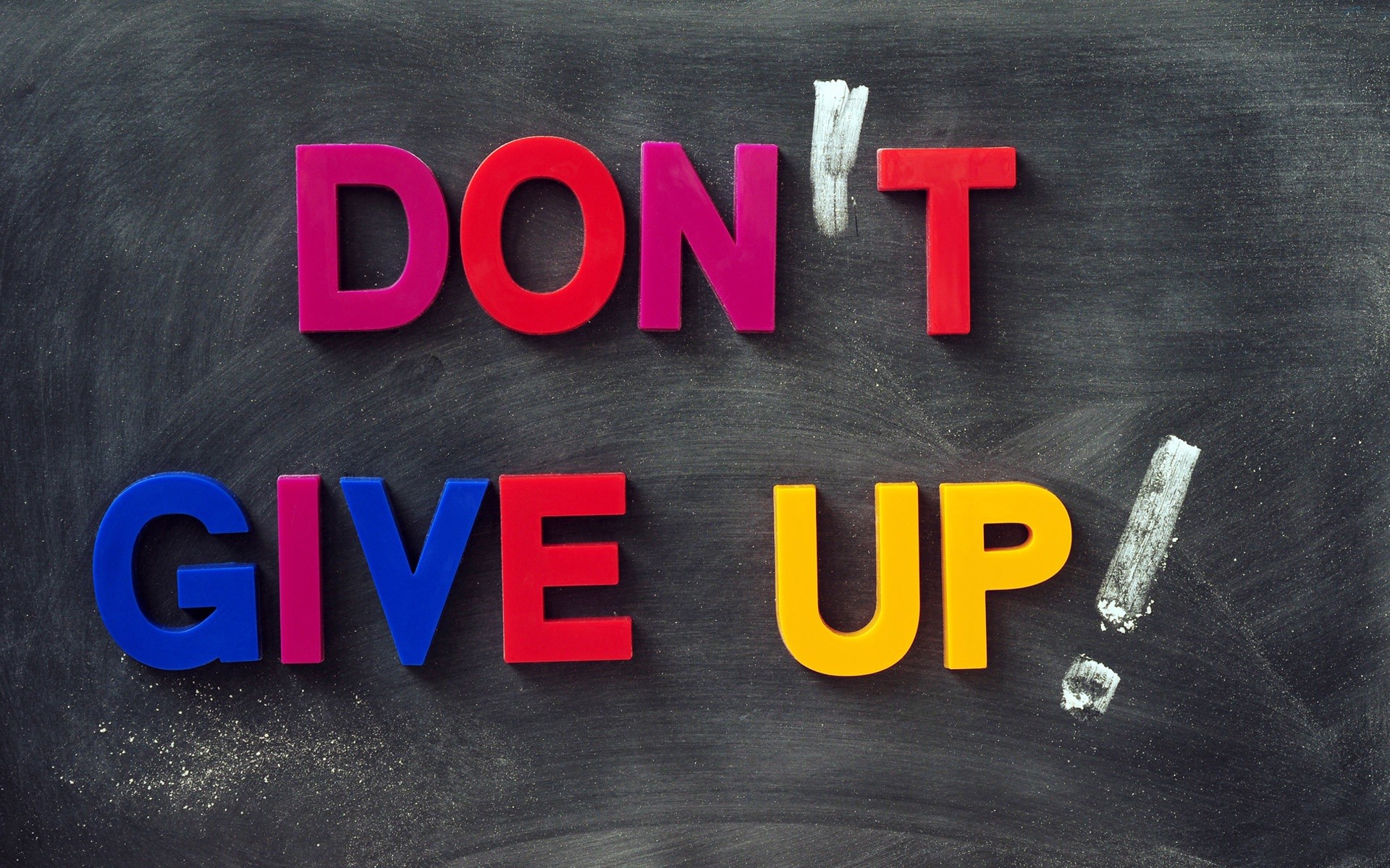 Colorful letters on a blackboard spell out 'Don't Give Up,' a motivational message for students