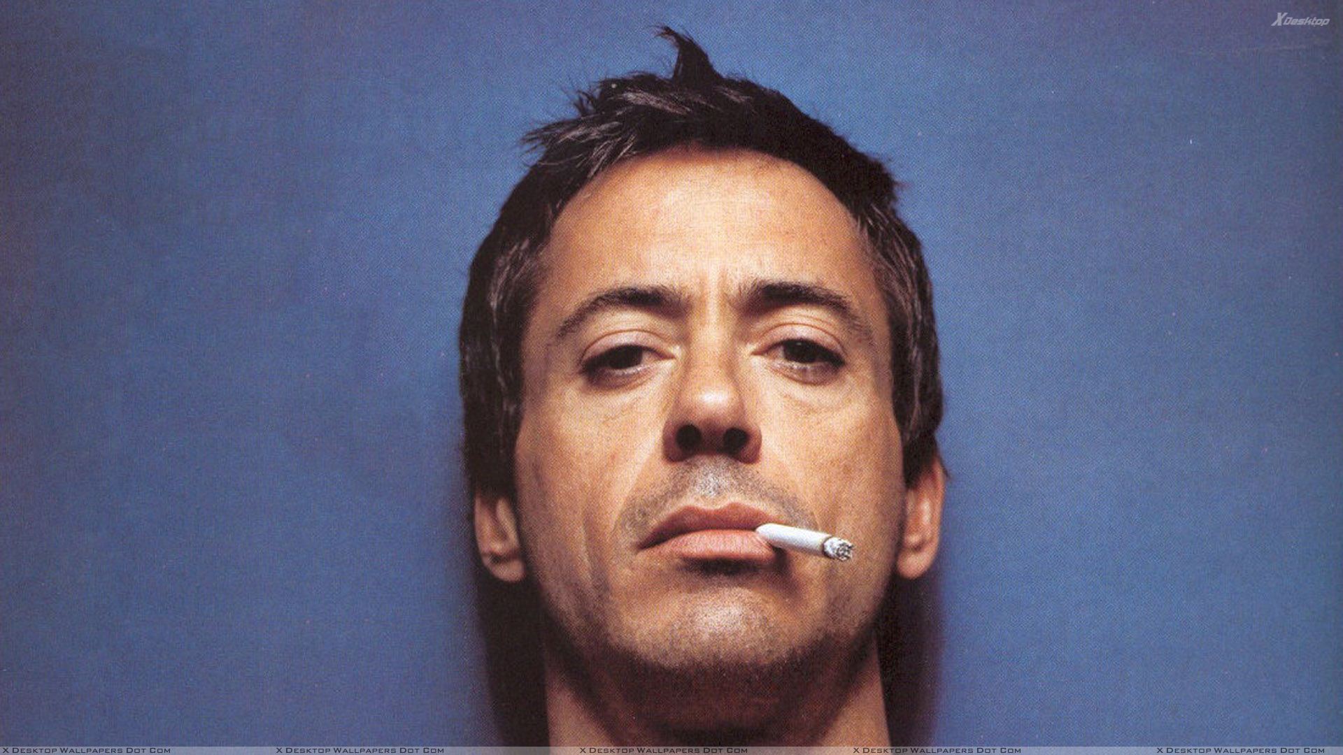 Robert Downey Jr Doing Smoking Face Closeup N Blue Background
