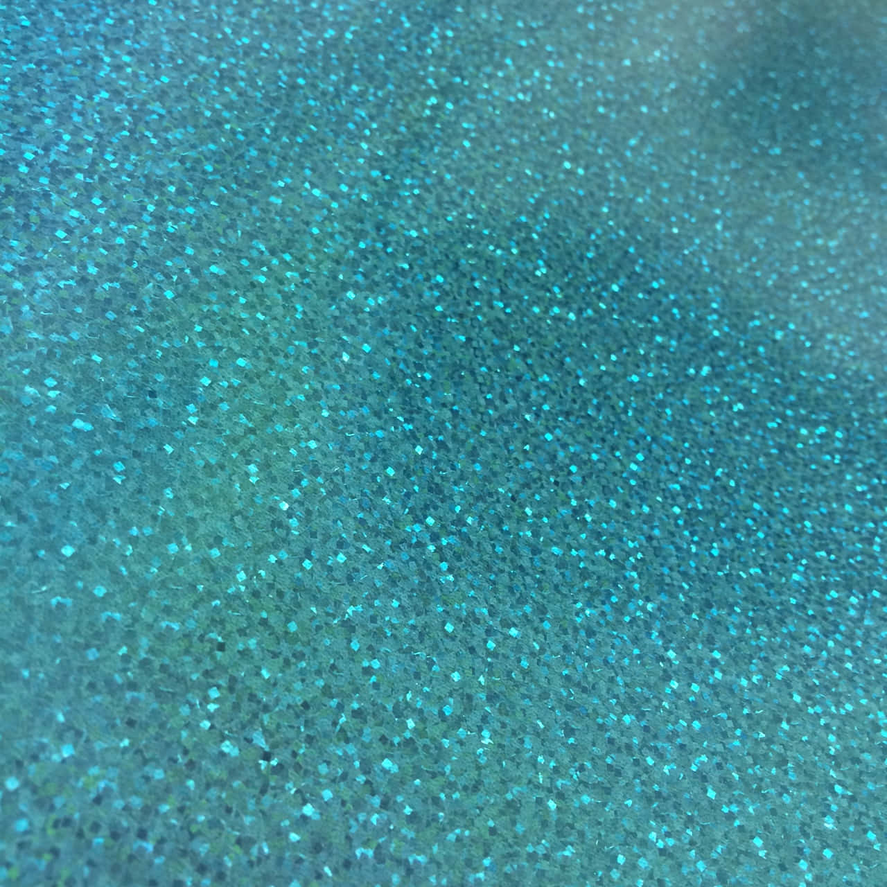 Close-up of a textured, glittery surface in a vibrant teal color