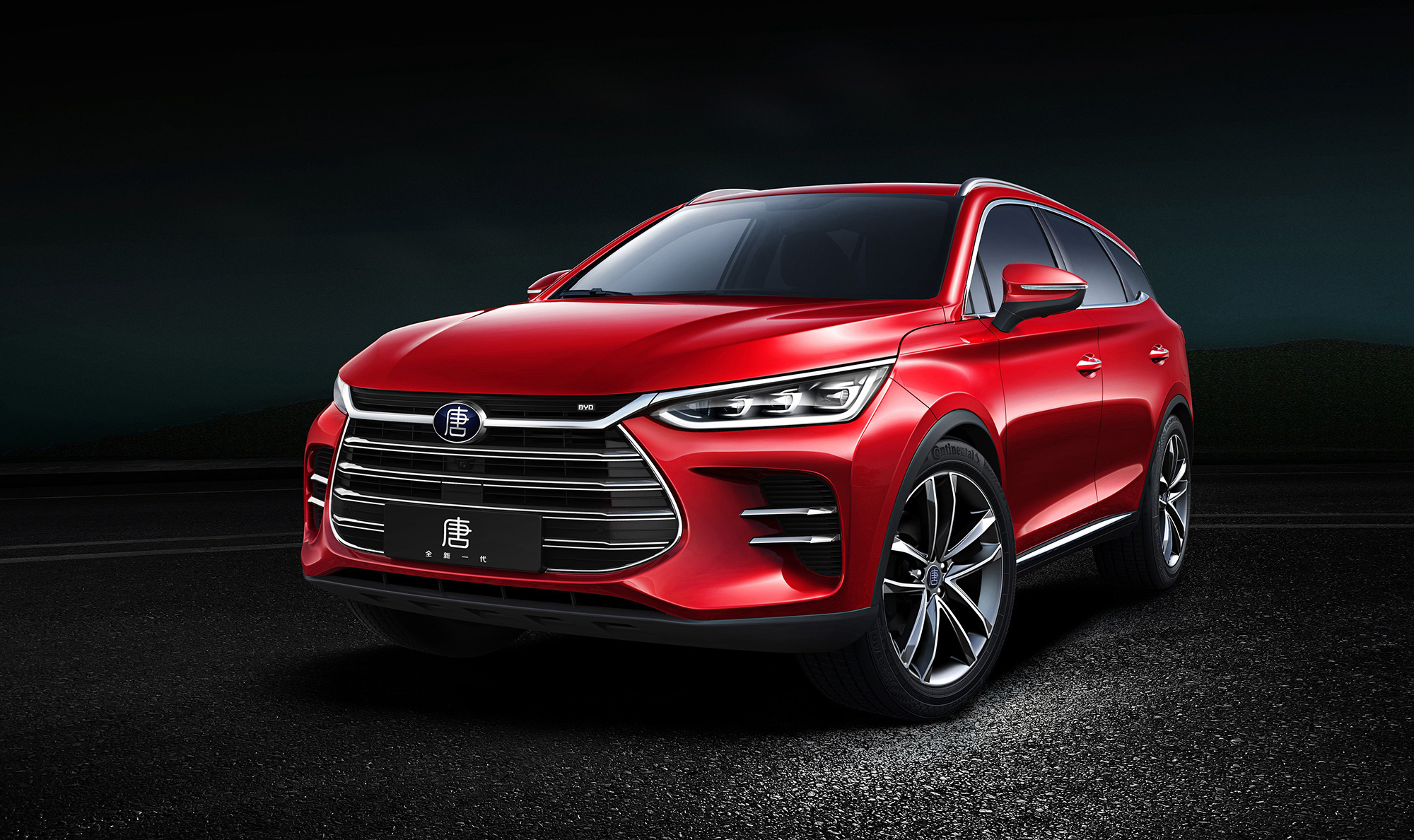 A vibrant red BYD Song Pro DM-i parked on a dark, textured surface, highlighting its sleek design and modern features