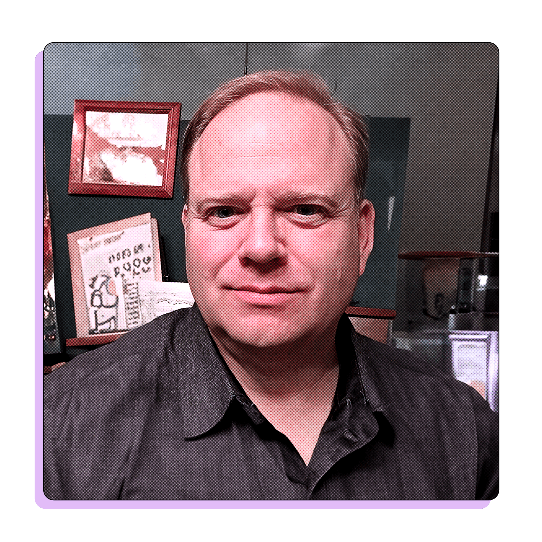 Portrait of a man in a dark shirt, possibly in an office setting