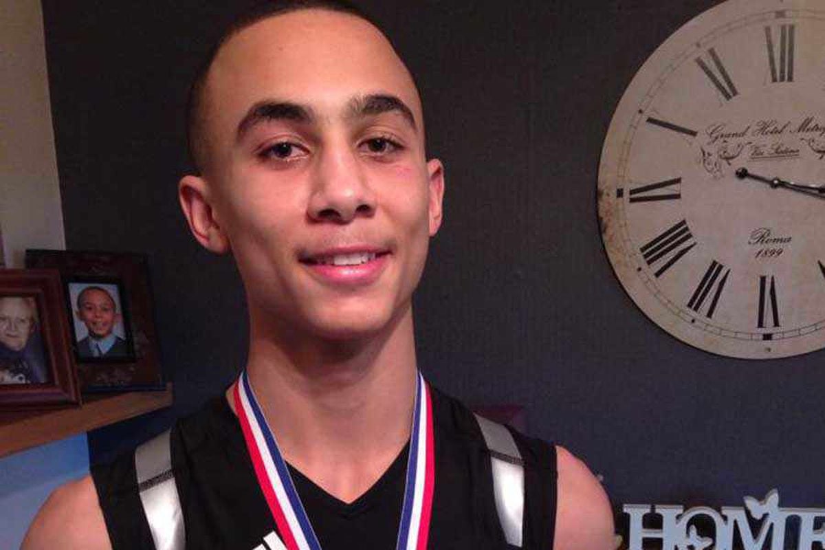 Benjamin Whittaker smiles at the camera, wearing a medal around his neck, in a casual setting