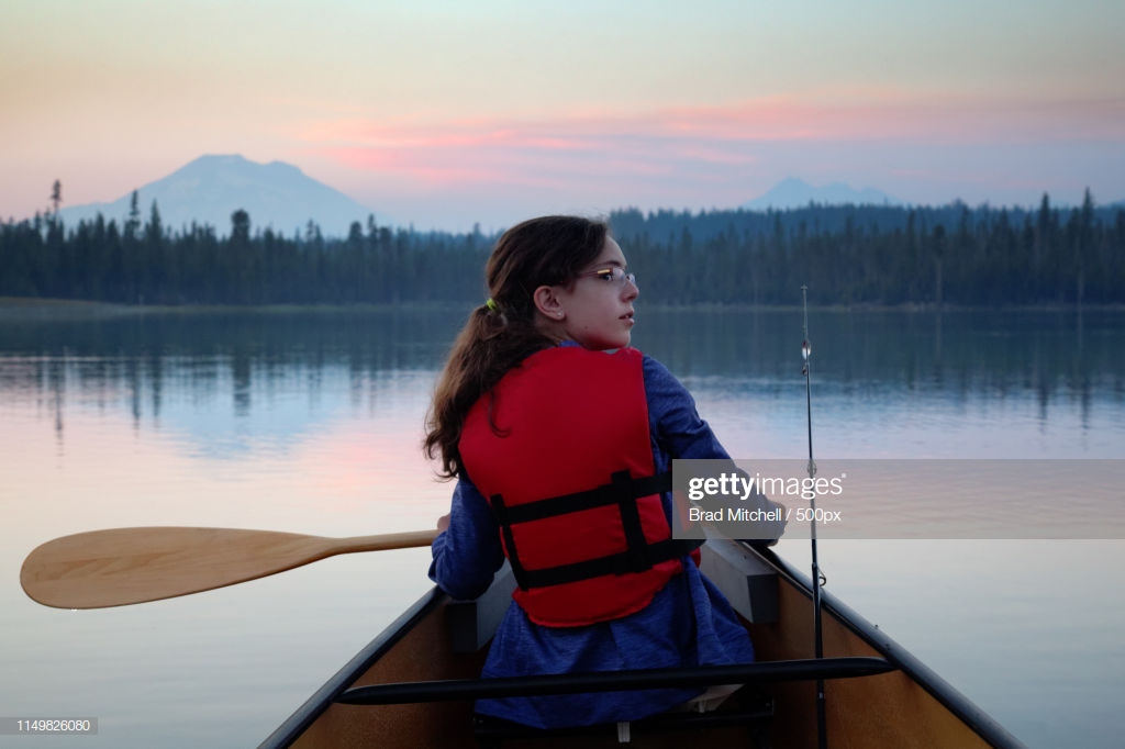 Girl Paddling Canoe On Hosmer Lake At Dusk Mountain Bachelor In