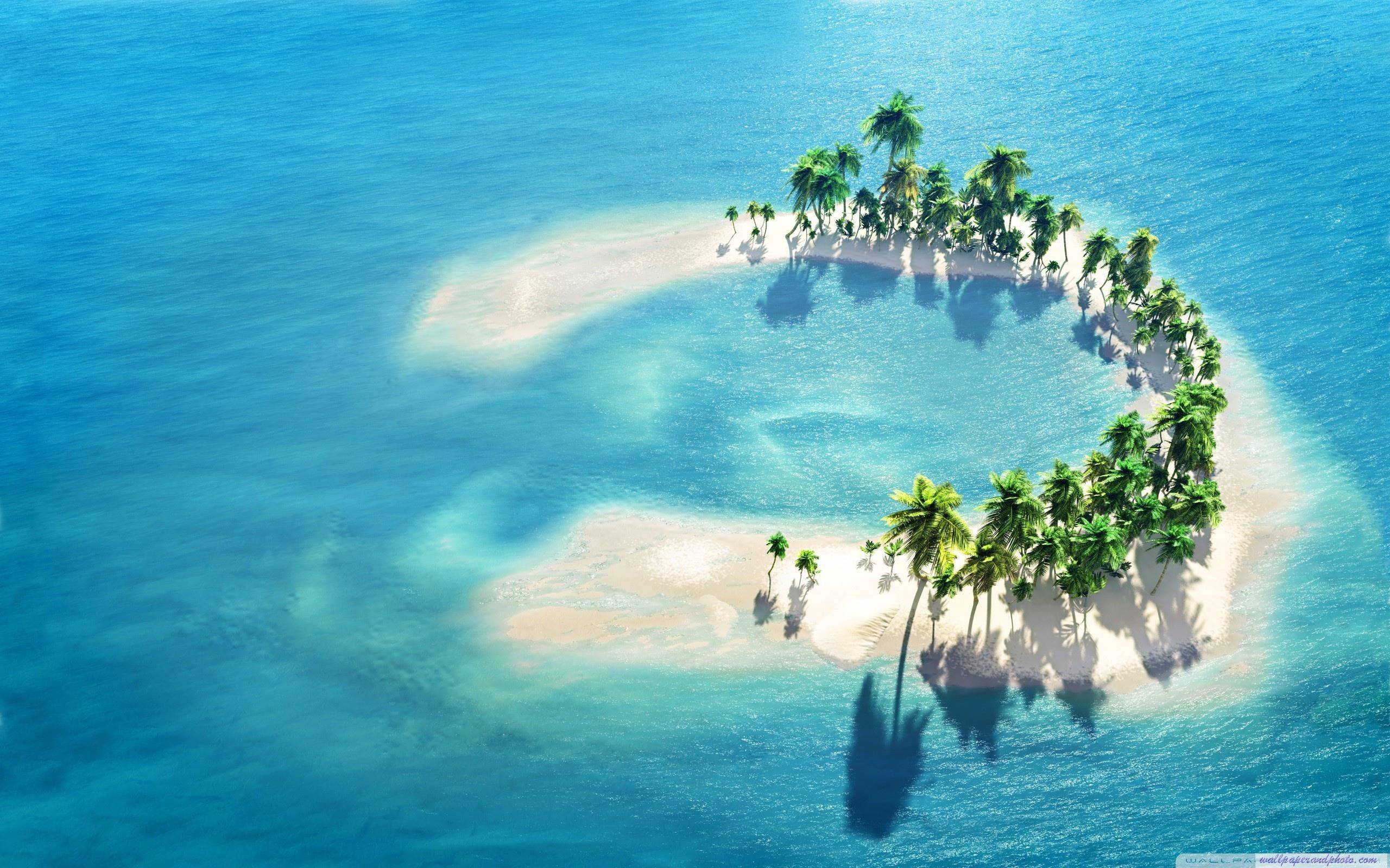 Aerial view of a crescent-shaped tropical island paradise with palm trees and white sand beaches, surrounded by clear turquoise water