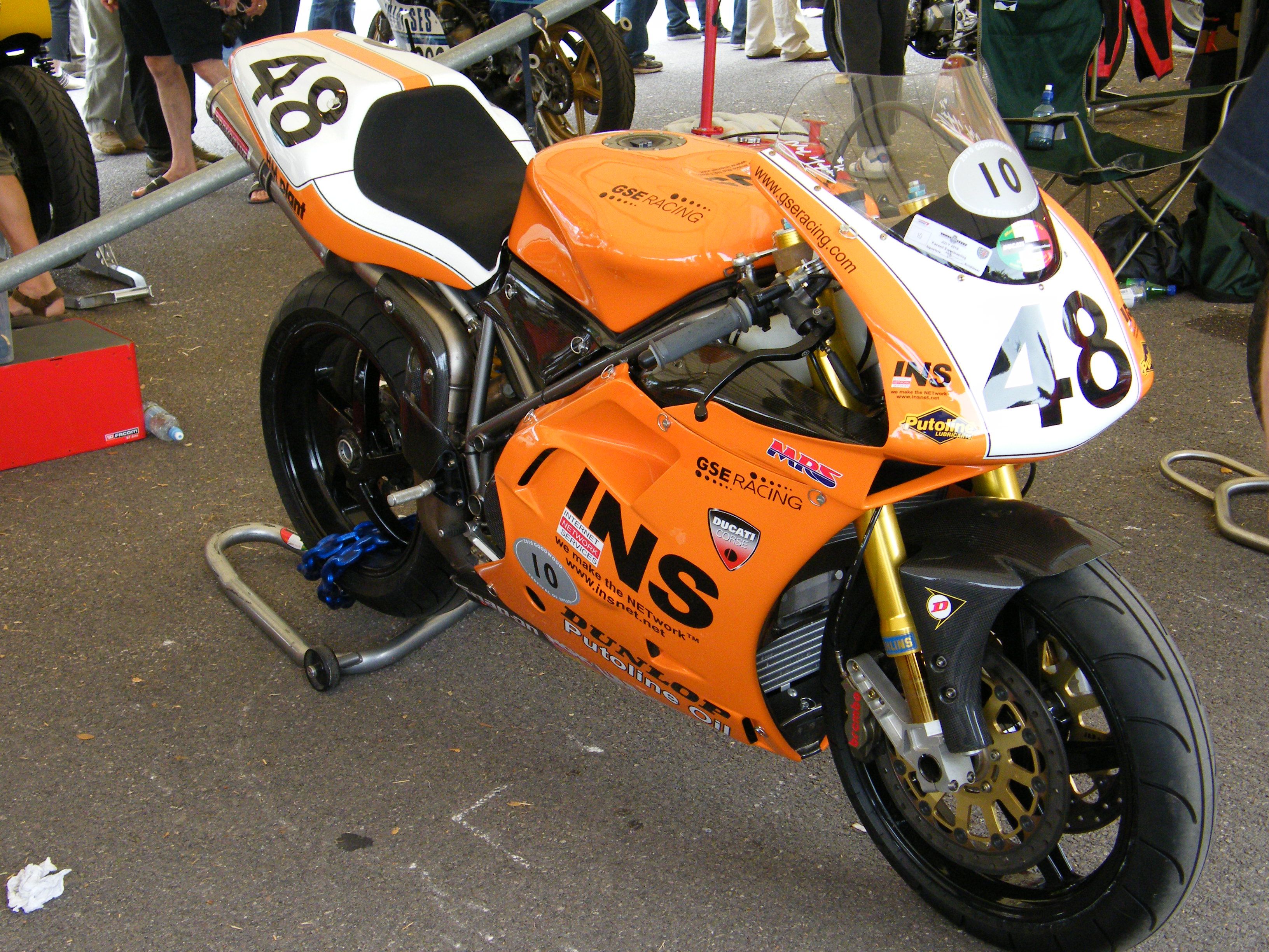 Orange and white Ducati 996 racing bike with number 48 on a track
