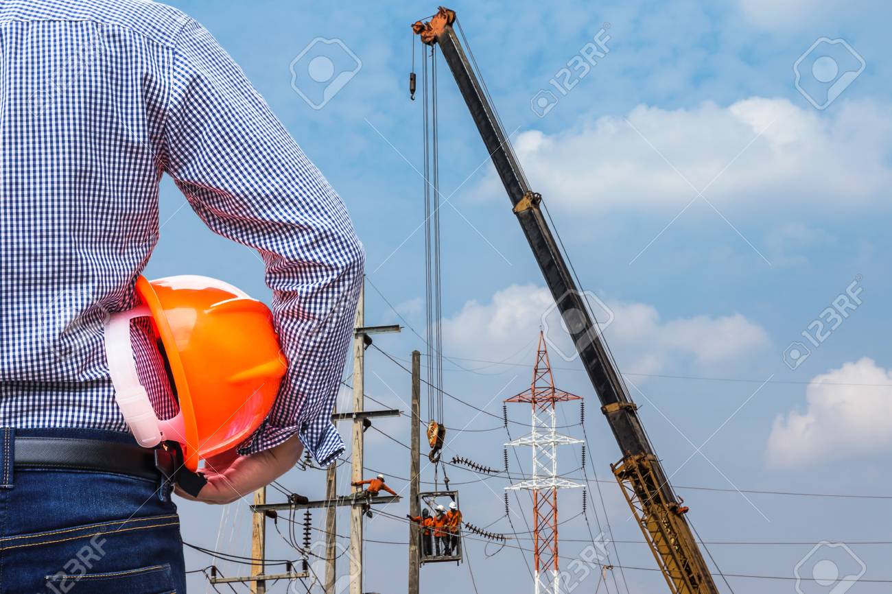 Electrical Engineer Holding Safety Helmet With Electrician Working