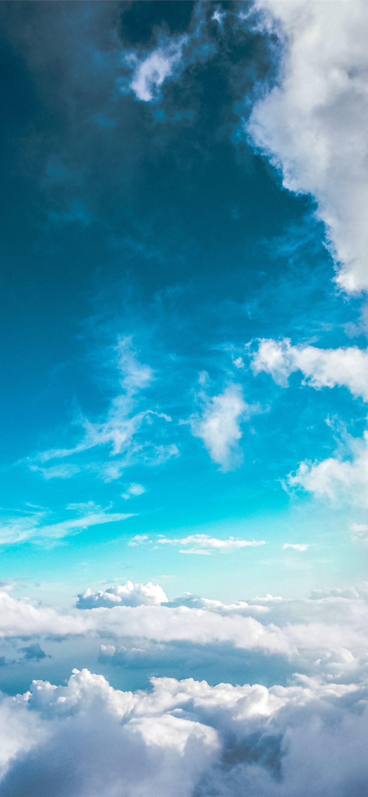 A breathtaking aerial view of a stunning cloudscape, with fluffy white clouds against a vibrant teal sky, perfect for an iPhone Pro 4k wallpaper