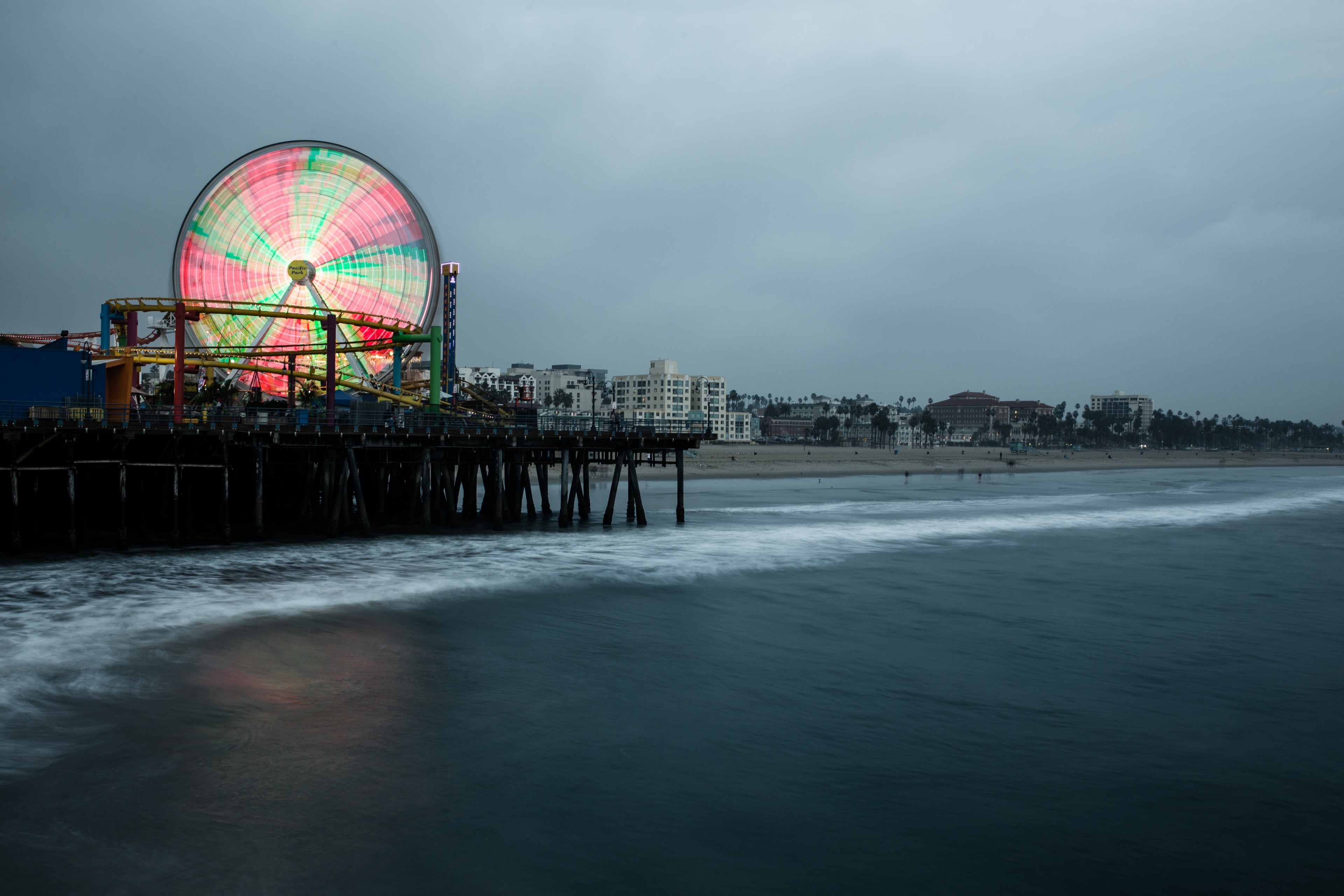 Big Colorful Ferris Wheel And A Rollercoaster At The Santa Monica Pier On Wallpaper