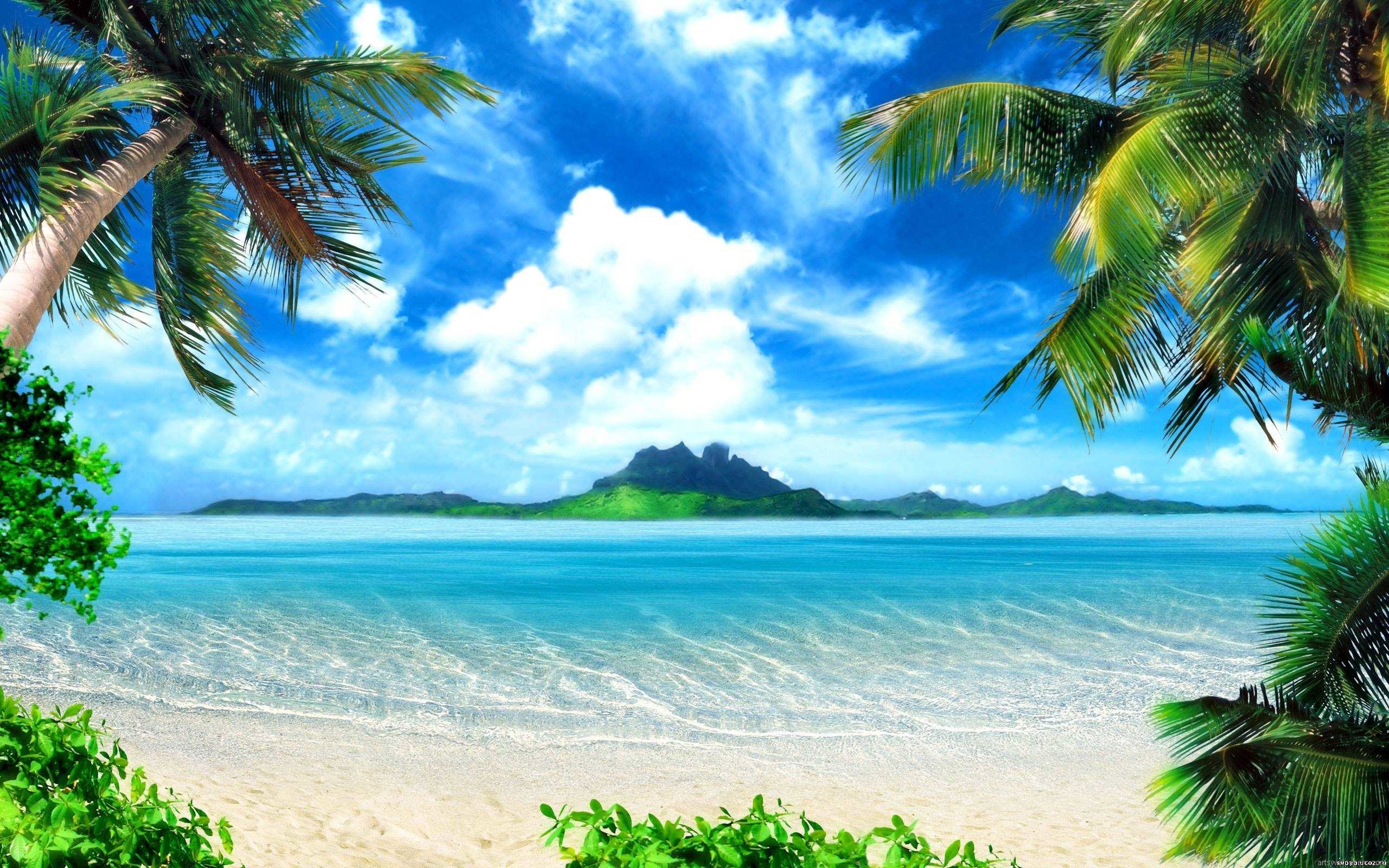 Tropical beach with crystal-clear water and lush green island in the background