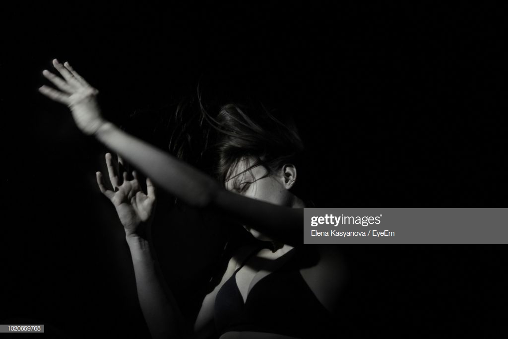 Seductive Woman Gesturing Over Black Background Stock Photo