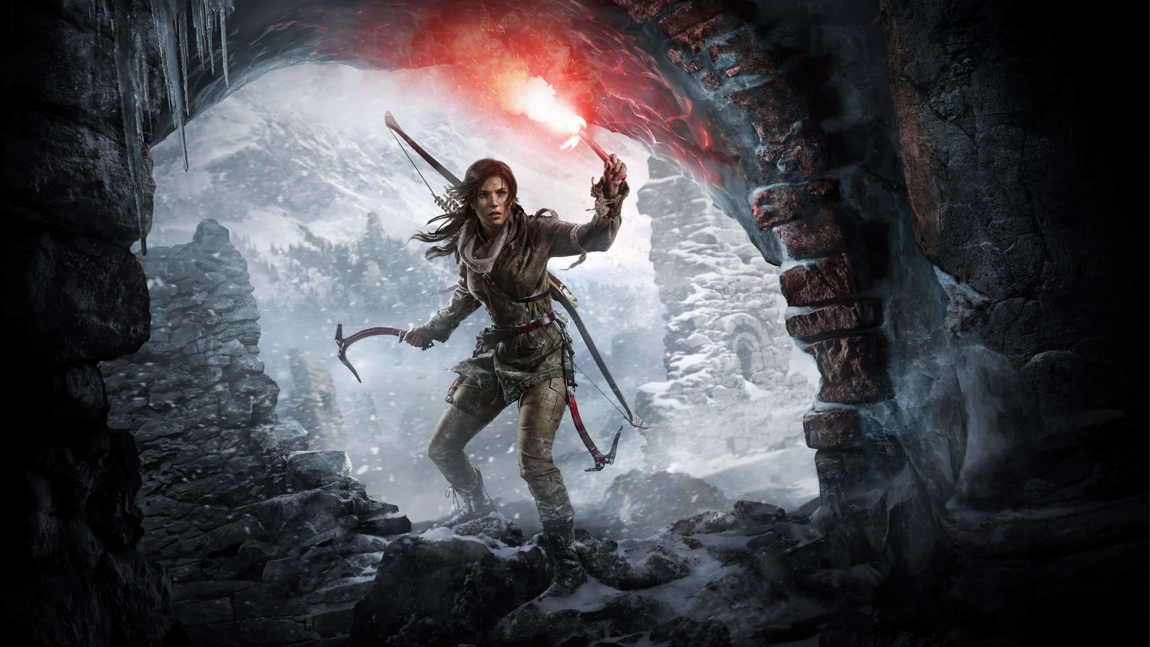 Lara Croft explores a snowy, mountainous landscape in a promotional image for Tomb Raider, holding a flare and her bow and arrow