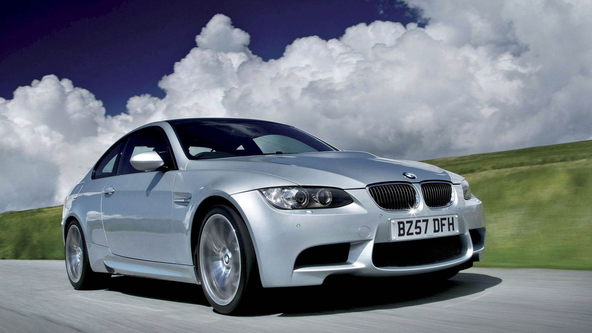 Silver BMW M3 Coupe driving on a scenic road