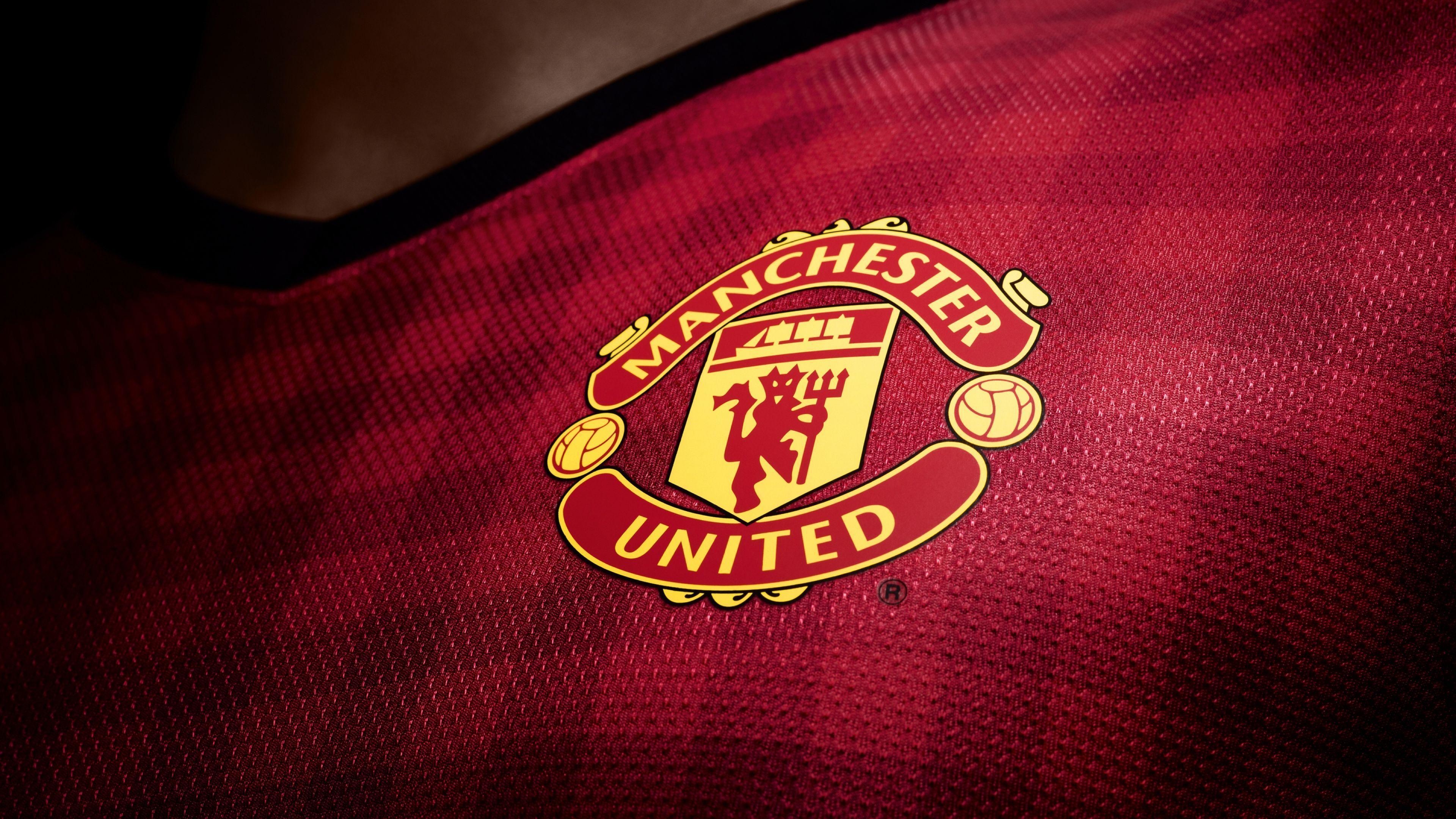 Close-up of a Manchester United jersey, highlighting the club's iconic crest on the vibrant red fabric