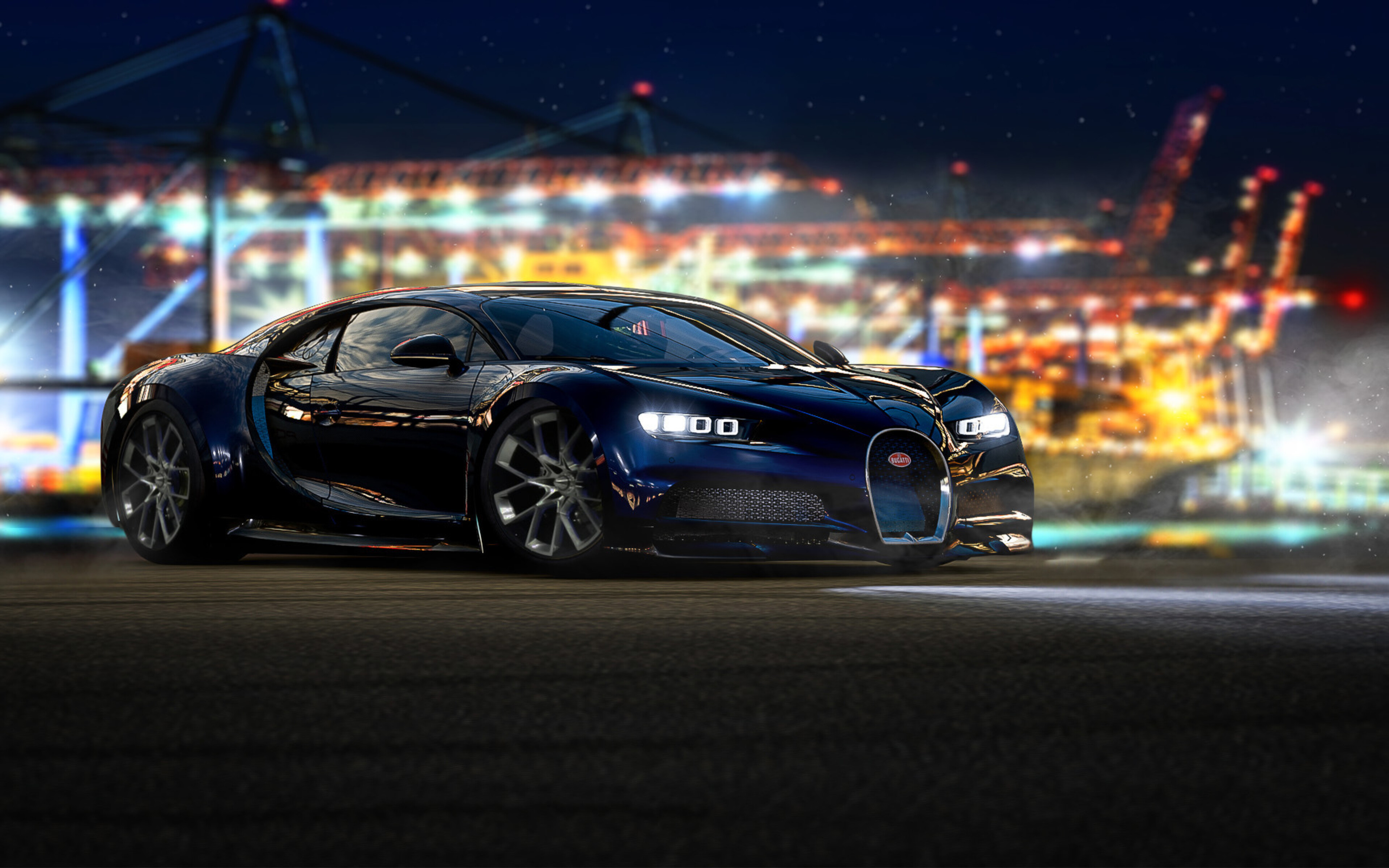 A sleek, dark blue Bugatti Chiron parked on a paved surface, with a blurred background featuring the illuminated cranes and lights of a harbor at night