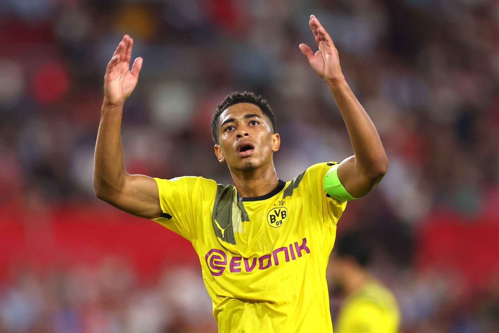 Jude Bellingham of Borussia Dortmund raises his hands during a match