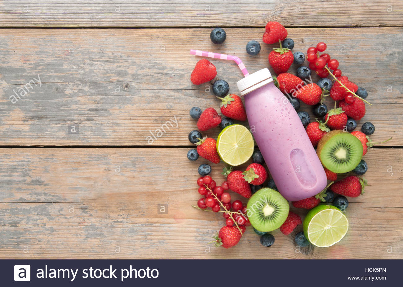 Berry Smoothie In A Bottle With Ingredients On Top Of Wooden