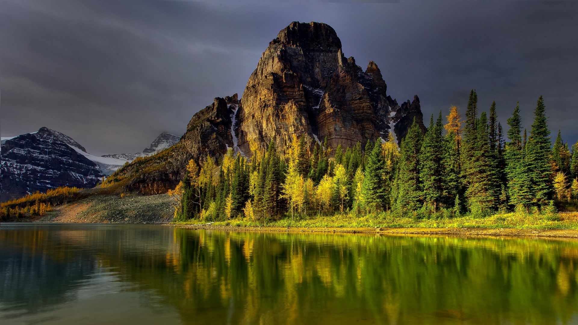 Stunning HD wallpaper of a majestic mountain reflected in a serene lake, surrounded by vibrant autumn foliage
