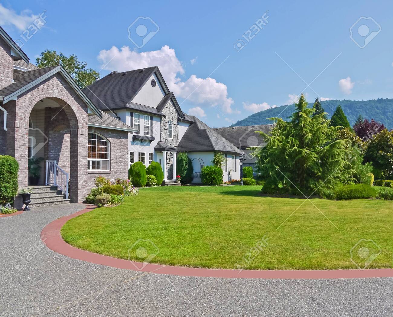Rounded Driveway And Lawn In Front Of Residential Houses On Blue