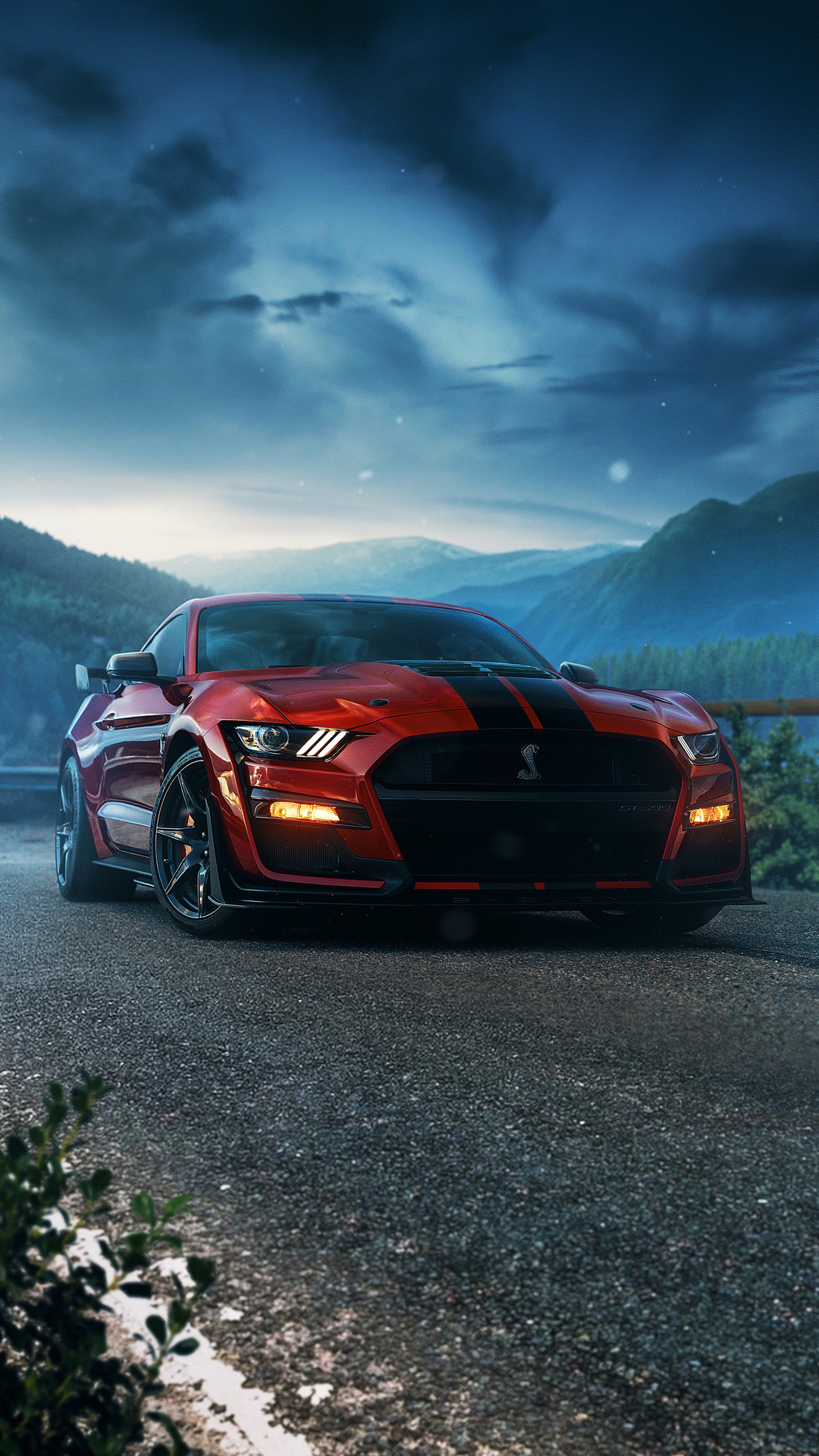 A red Ford Mustang Shelby GT500 parked on a mountain road at dusk