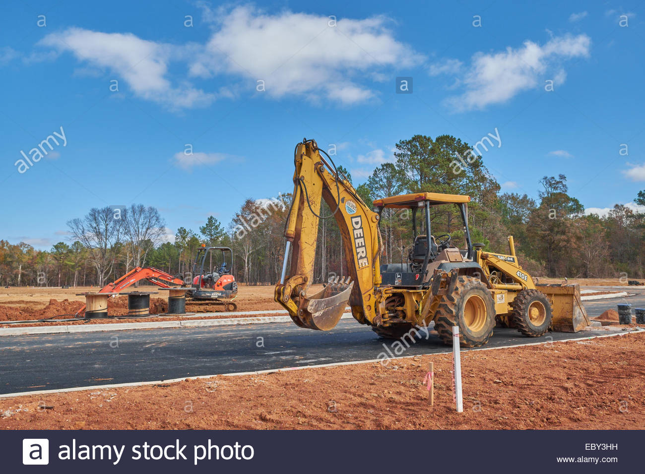 A John Deere Backhoe Front Loader In The Foreground With