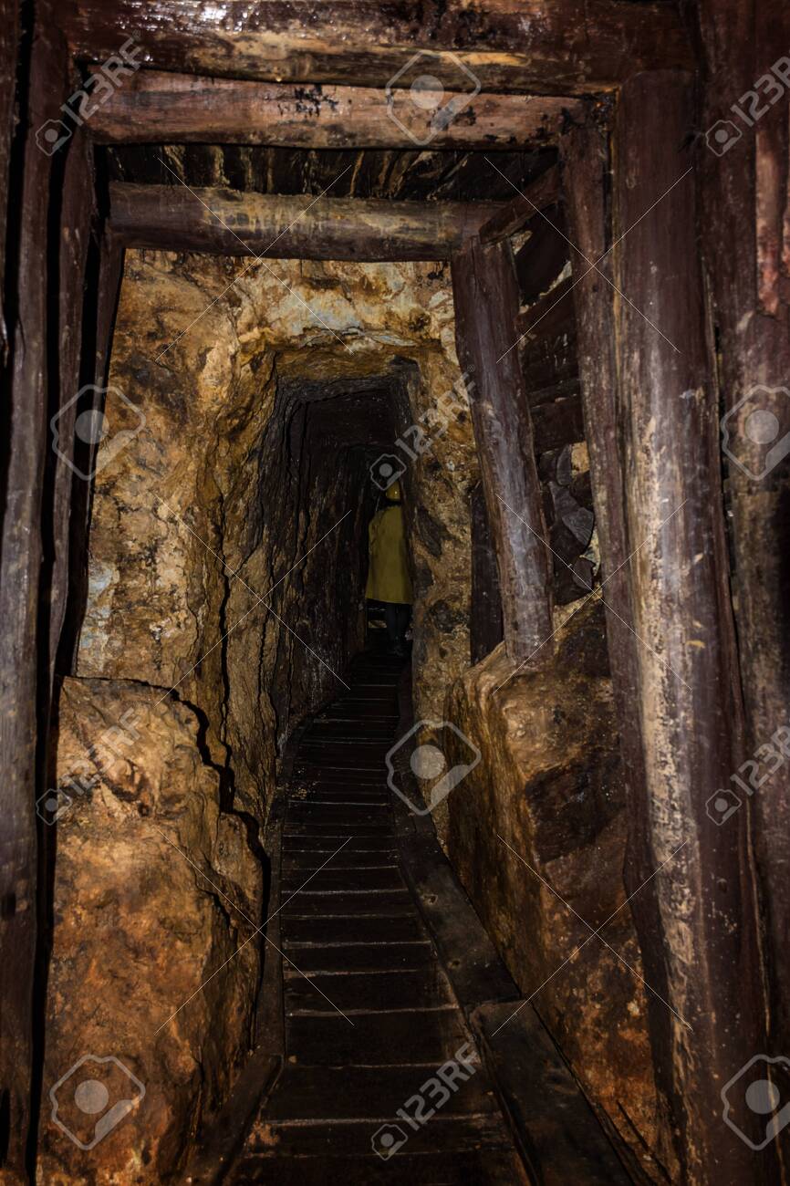 Old Mine Shaft With Wooden Timbering And Person Dressed In A