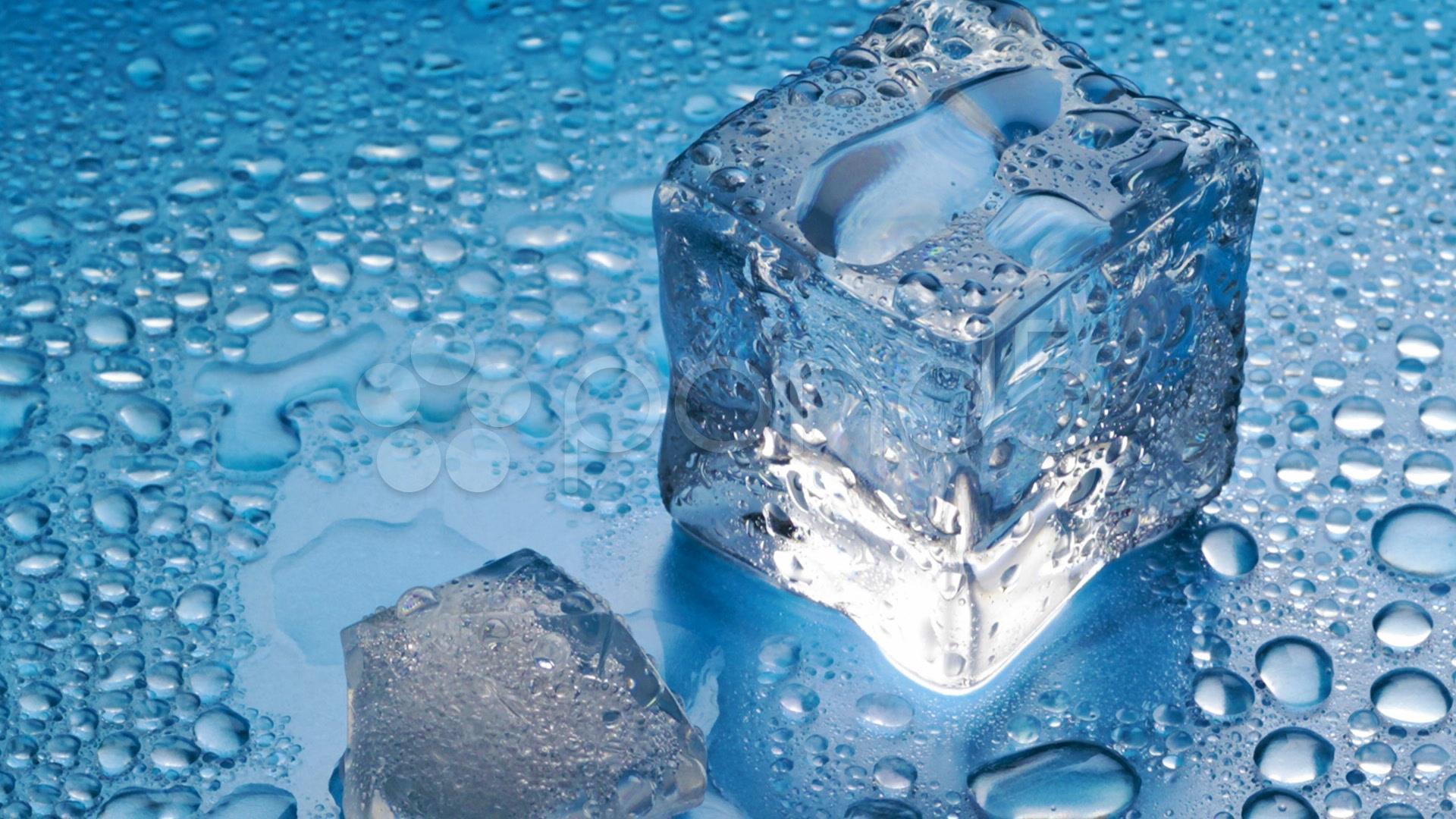 Close-up of ice cubes on a blue surface with water droplets, creating a refreshing and cool visual