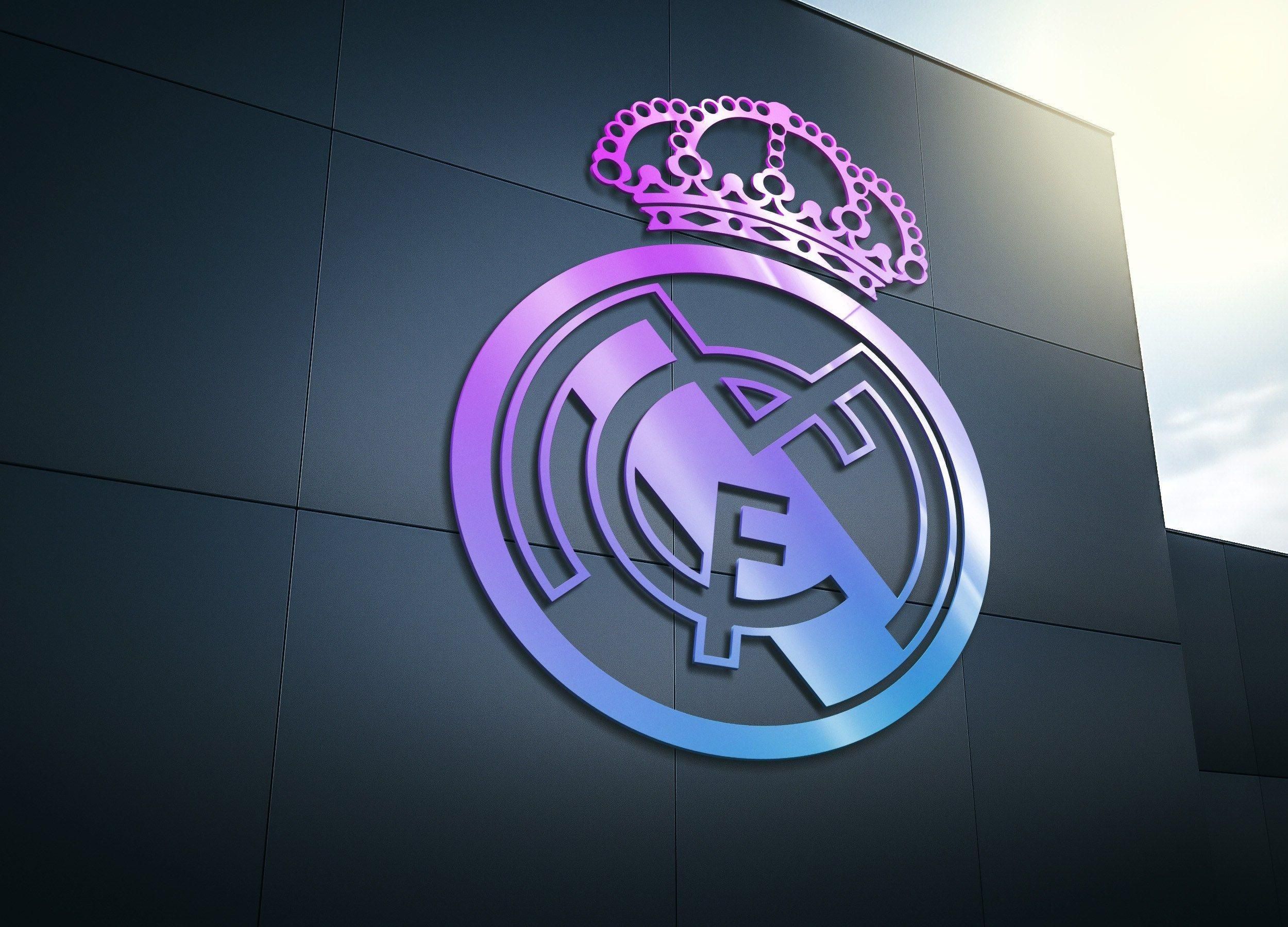 A vibrant, stylized Real Madrid logo in a gradient from purple to blue, displayed prominently on a dark, modern facade. It features the iconic crown and circular emblem, radiating a sense of regal sophistication