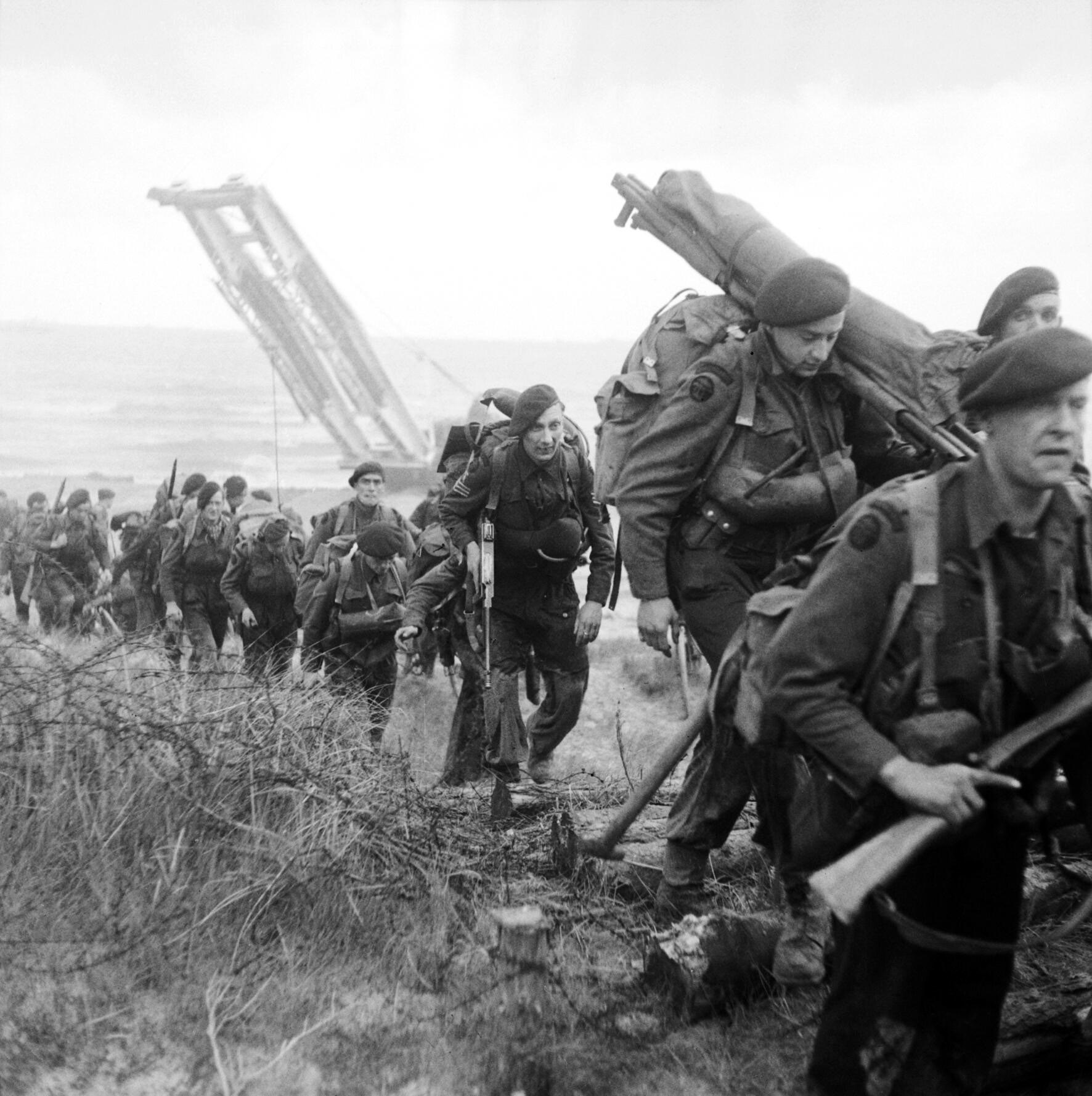 World War II era photograph of French Commandos Marine troops disembarking from a landing craft and advancing along a beach, likely during a raid or amphibious assault