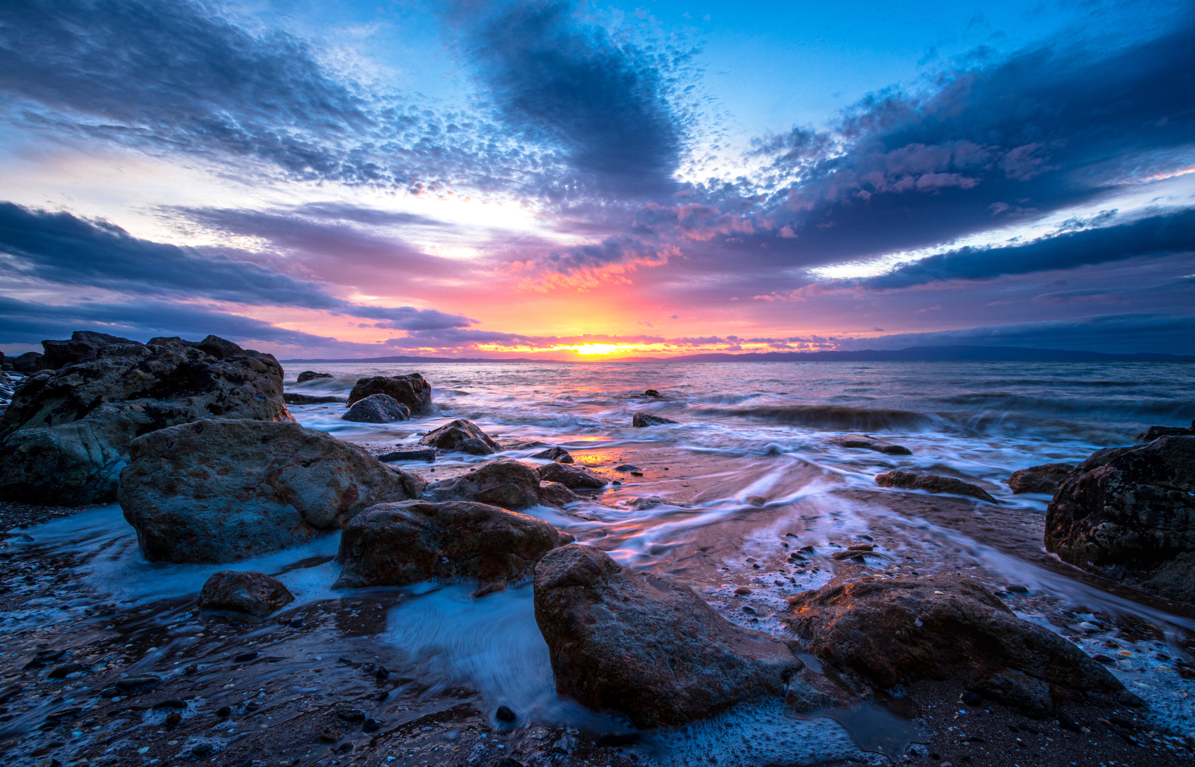 Rocky seashore at sunset with colorful sky