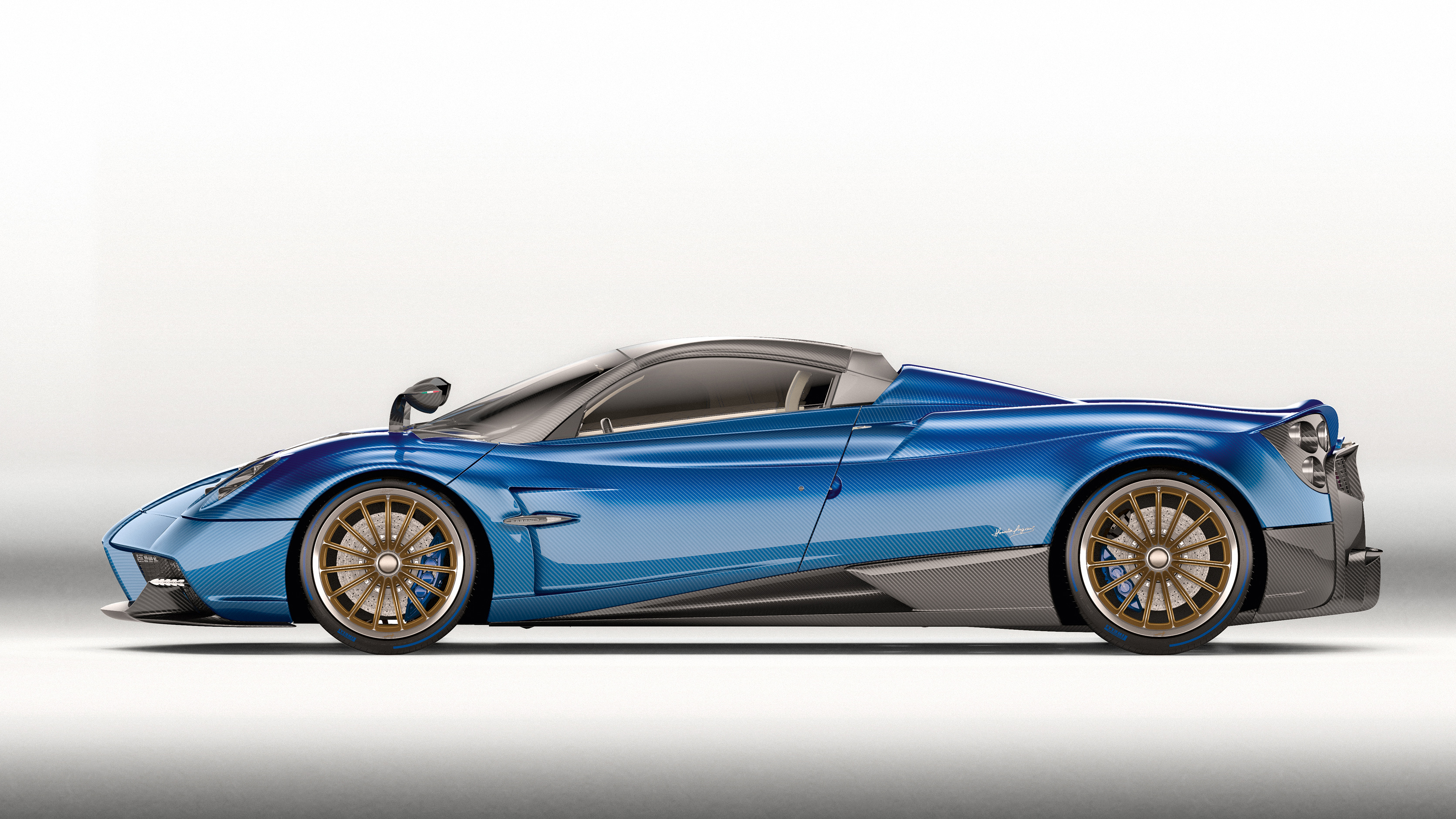 A side view of a blue Pagani Huayra Roadster against a white background, showcasing its sleek design and gold-colored wheels