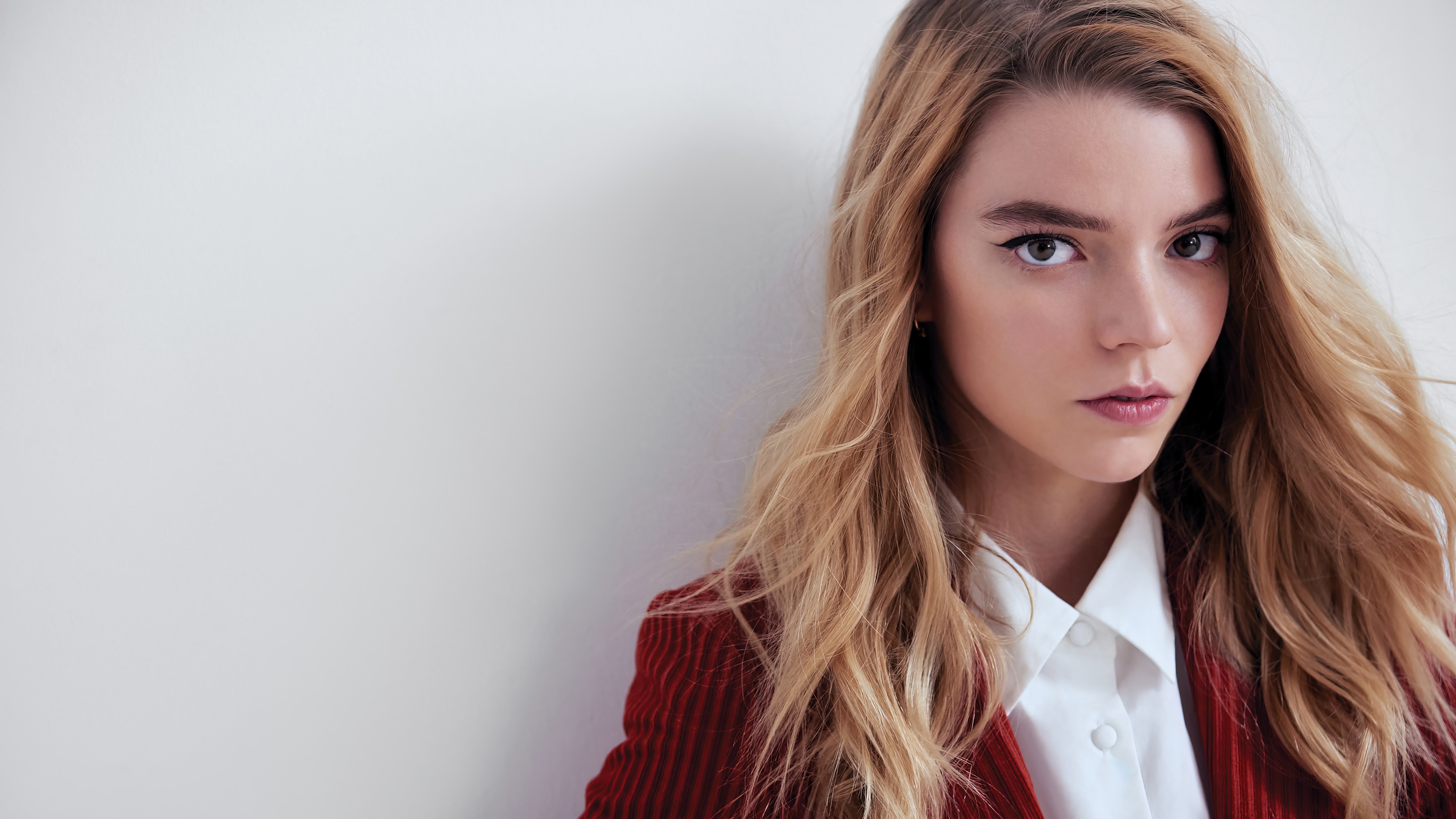 Anya Taylor-Joy posing against a white wall