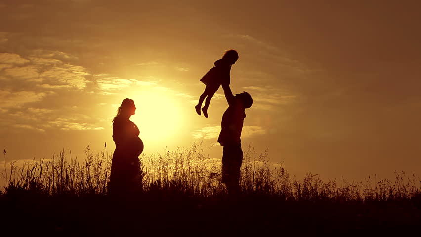 Happy Family Father Mother And Baby Playing At Sunset