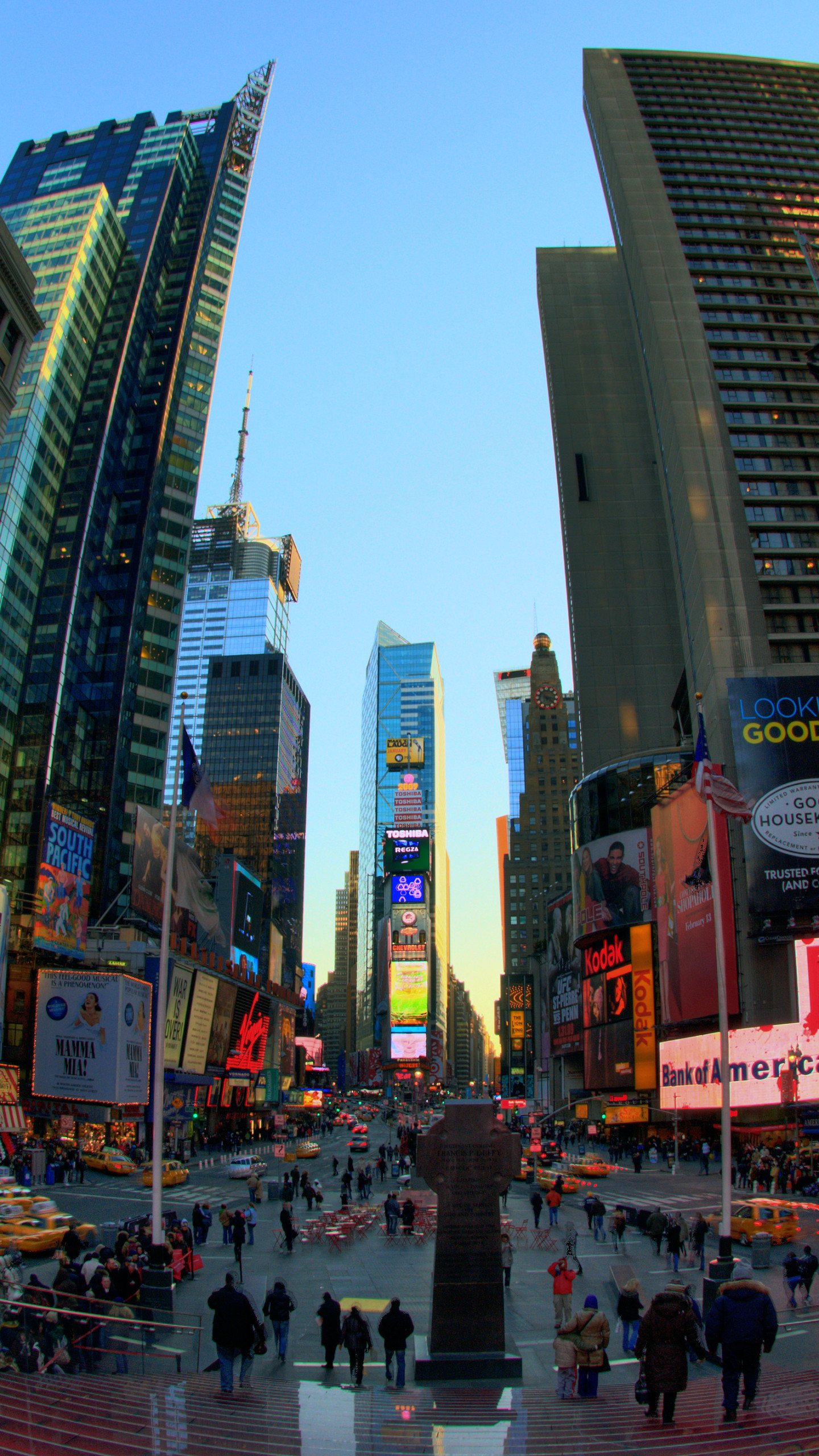 A vibrant fisheye view of Times Square in New York City, showcasing the bright lights, billboards, and bustling crowds at dusk